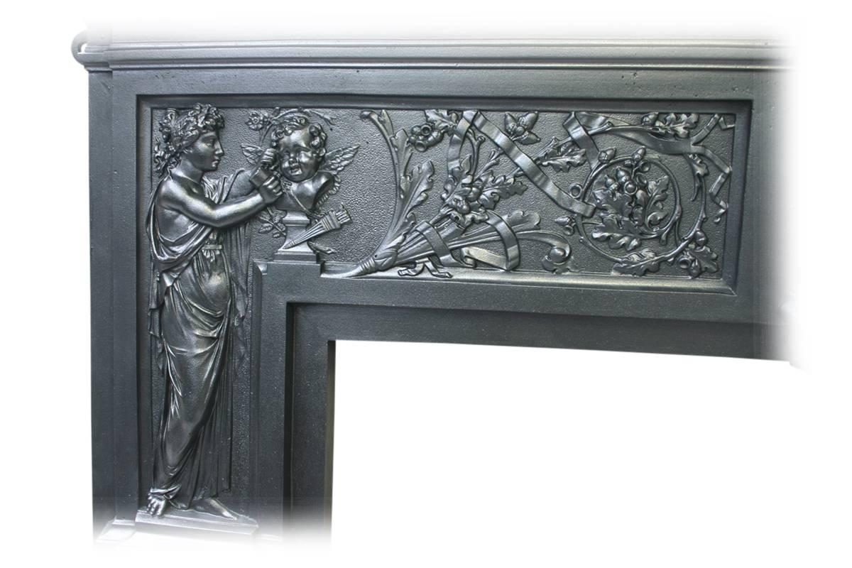 Arts and Industry, a large ornate Victorian cast iron fireplace surround. Each leg is finely cast with a main panel. The left jamb depicting a Grecian lady carving a marble bust of a cherub with further branches of oak bearing acorns amongst