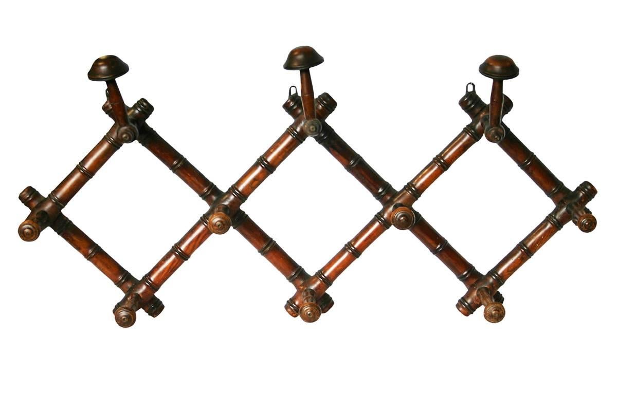 Early 20th century French faux-bamboo folding hat and coat rack. Complete and in excellent condition with good patina and color, circa 1900.
Measures: 84cm wide x 48cm high x 17.5cm deep (folded 22cm wide).
  