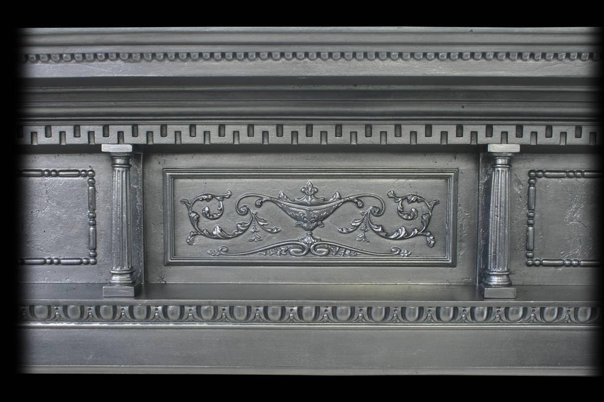 Antique Victorian cast iron fireplace surround with Corinthian pilasters terminating in rosette capitals, the under shelf is supported by a pair of small pillars.