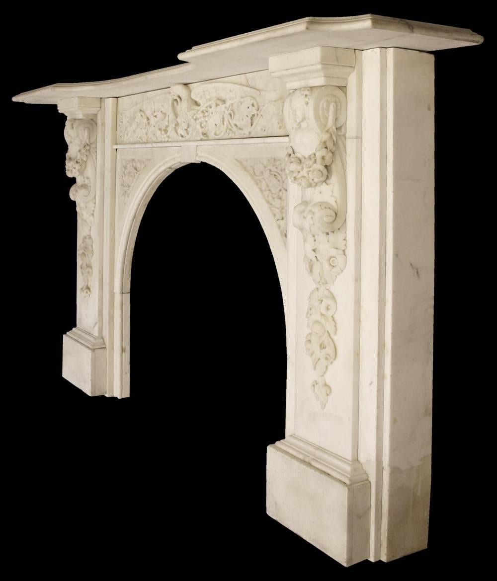 A spectacular large antique early Victorian chimneypiece in ivory white statuary marble. The intricately carved frieze in high relief shows a long grape vine in fruit being held by a spread eagle, which sits above equally well carved spandrels, and