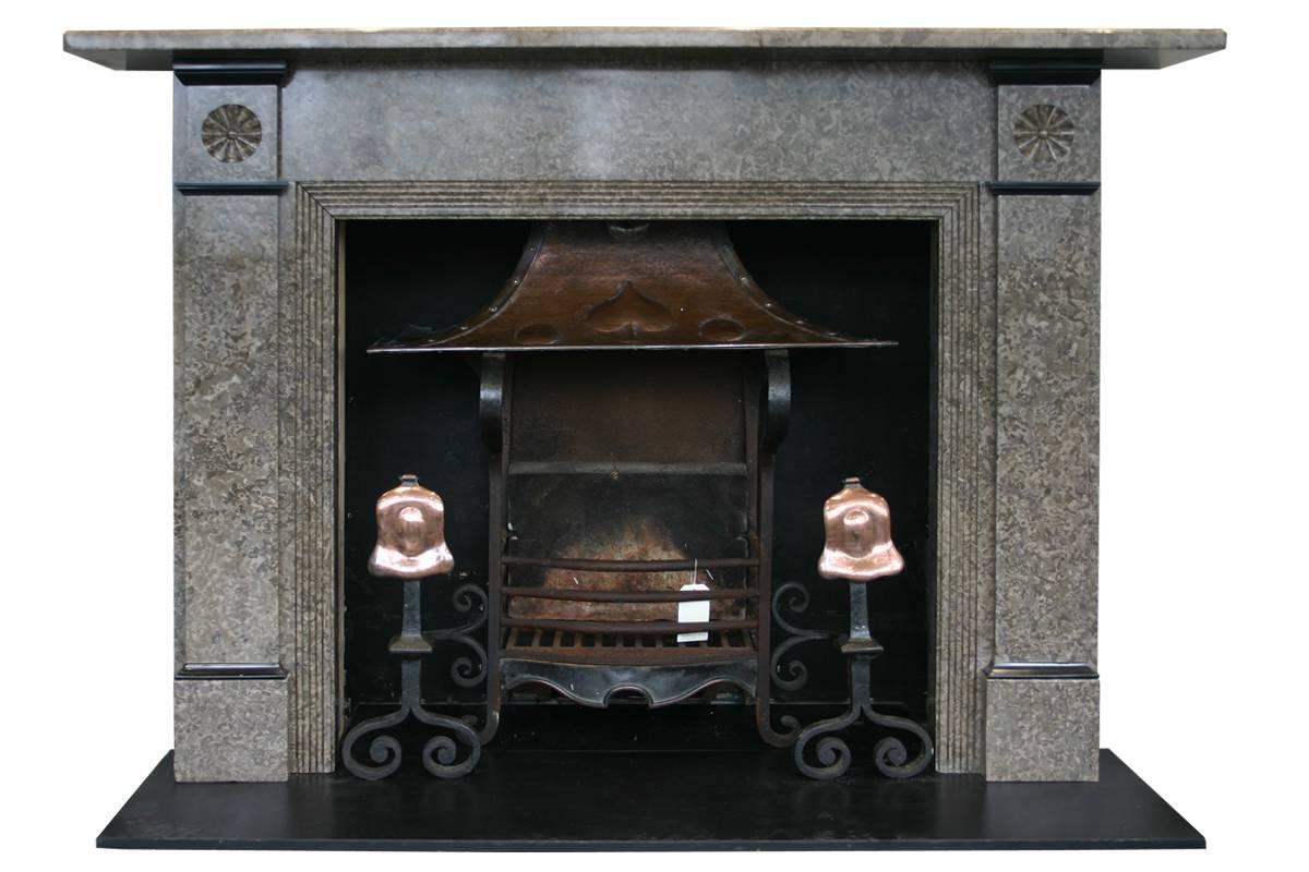 Large but elegant antique Edwardian Derbyshire limestone fireplace surround with rosette carved capitals, reeded returns and black marble interruptions. Pictured with a unusual Arts and Crafts copper canopied fire basket, sold separately.