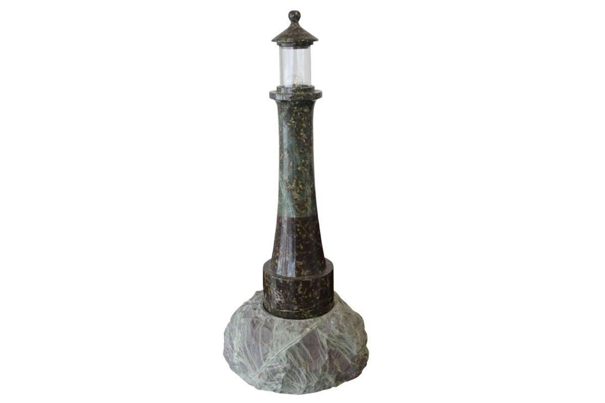 Tall mid-20th century Cornish granite lighthouse lamp. The unworked 'rock' base supports tapering polished body terminating in cylindrical glass shade capped by polished granite roof, circa 1950. Measures: 60cm high x 26cm wide at base.