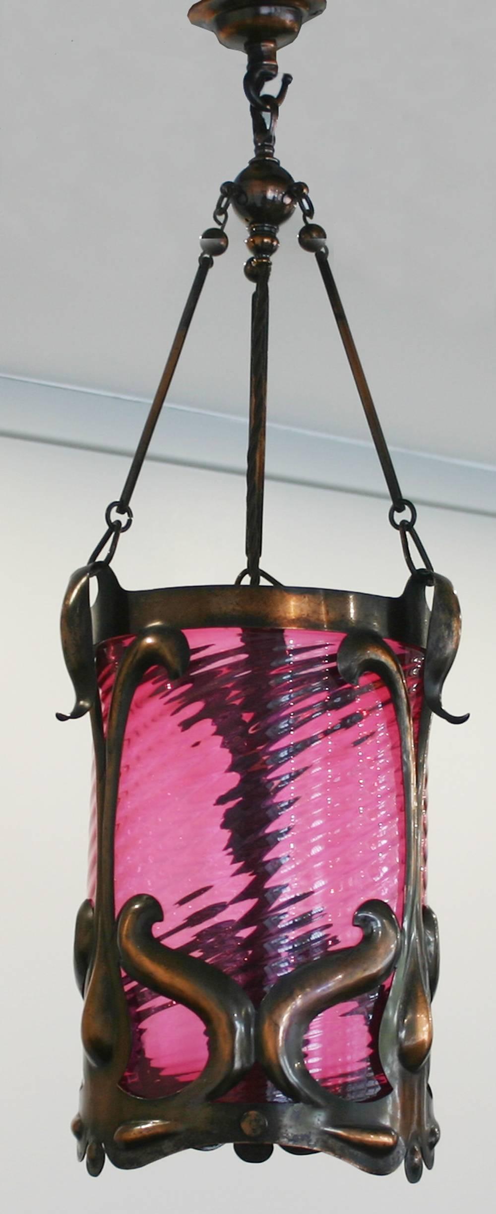 Antique Edwardian Art Nouveau hall lantern. Fine copper frame with beautiful patina hold a spiral cranberry glass shade.