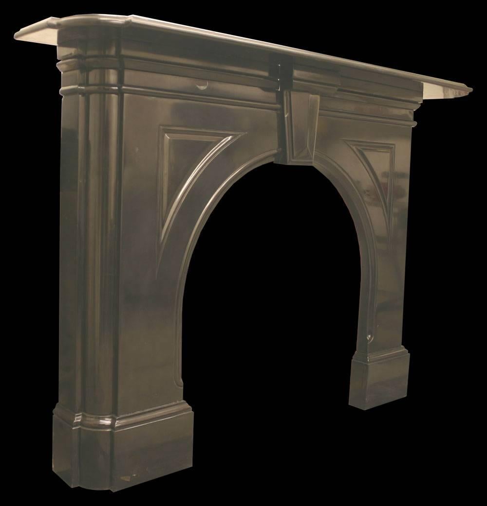 A fine antique mid-Victorian Irish black marble fireplace with an arched aperture this piece has many interesting details, including quarter-round outside returns and complex undershelf mouldings.