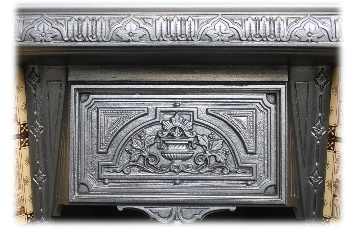 Restored 19th century cast iron fireplace grate with well cast detail throughout, circa 1895. Complete with an original set of antique fireplace tiles.

This grate has been finished the traditional black grate polish, leaving a gun metal / pewter