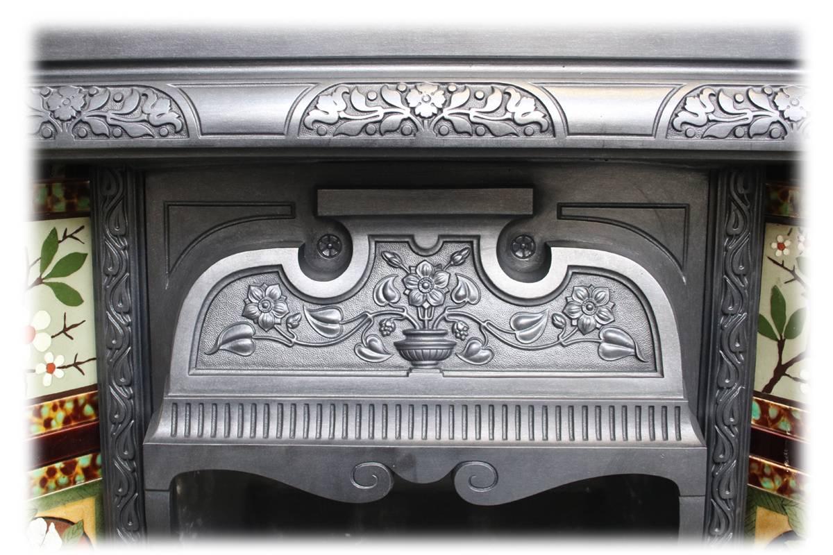 Reclaimed late Victorian cast iron fireplace insert with a large well shaped cast iron canopy, circa 1880. Complete with an original set of antique fireplace tiles.

This grate has been finished the traditional black grate polish, leaving a gun