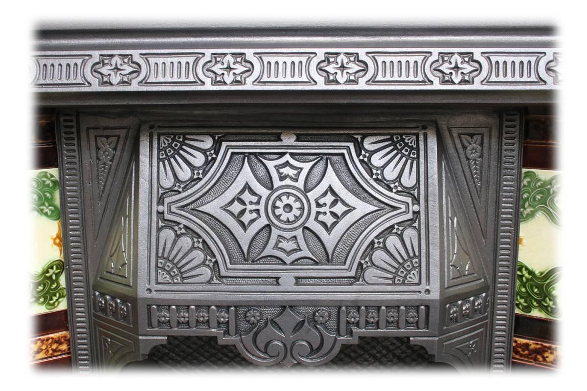Late Victorian cast iron and tiled grate in the Aesthetic manner. Complete with an original set of antique fireplace tiles.

This grate has been finished the traditional black grate polish, leaving a gun metal / pewter shine. Alternative finishes