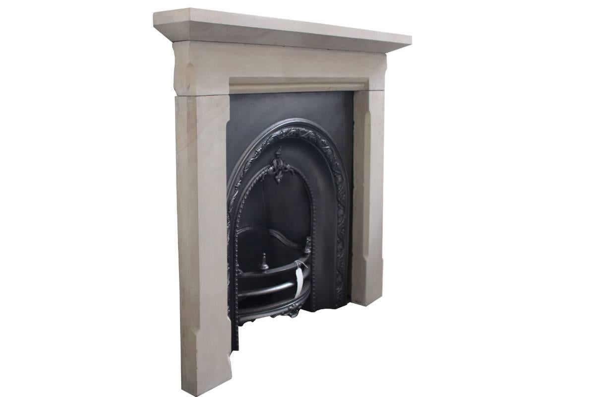 Late Georgian sandstone fire surround of simple four-piece construction with chamfers to the legs. Good color throughout. The original shelf fixings have been cleaned and new steel brackets made to suit. 
Pictured with an original cast iron insert