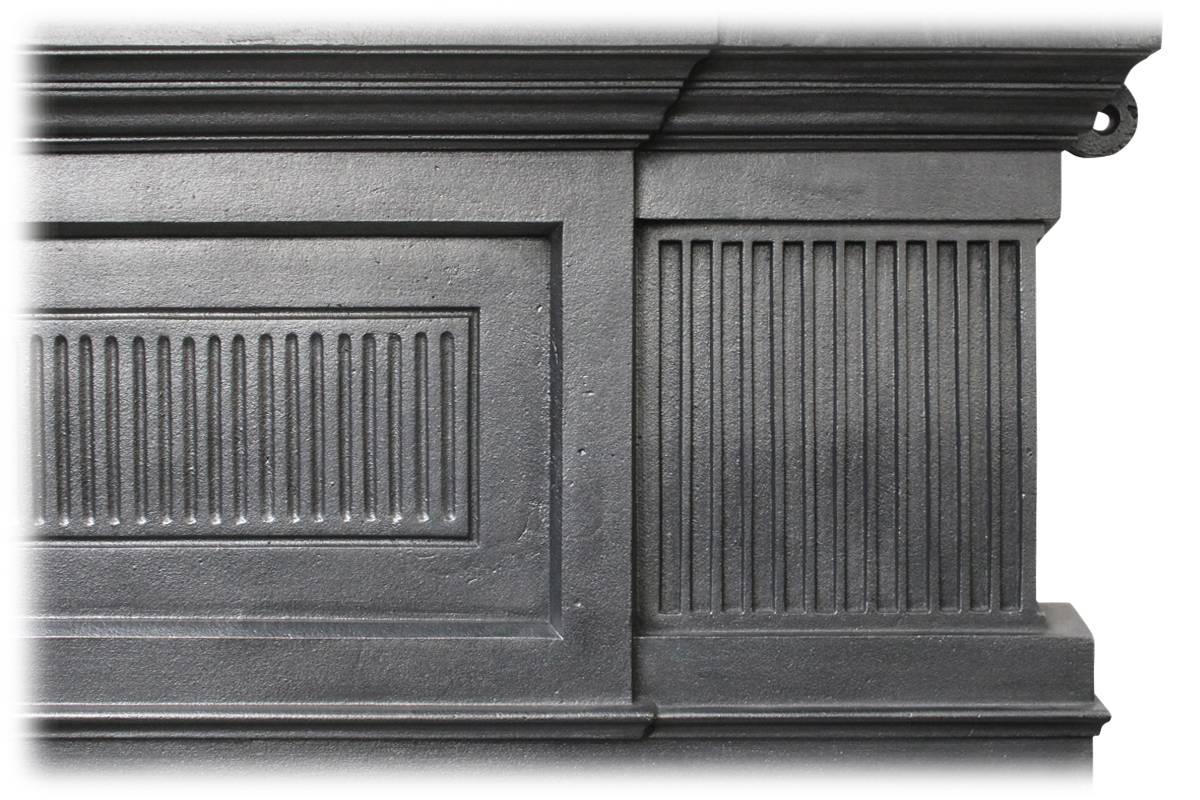 Reclaimed Edwardian cast iron and tiled combination grate, the breakfront frieze decorated with fluted panels, complete with its original cast iron overmantle with the original beveled mirror plate in excellent condition. This fireplace is complete