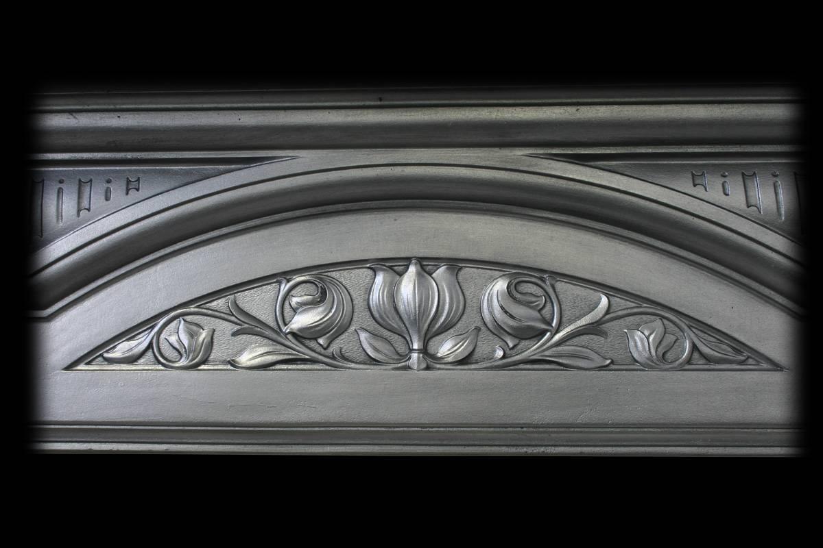 Antique Edwardian Art Nouveau cast iron fireplace surround with a stylized tulip to the frieze and simple frame.

The surround has been finished with traditional black grate polish leaving a gun metal look.