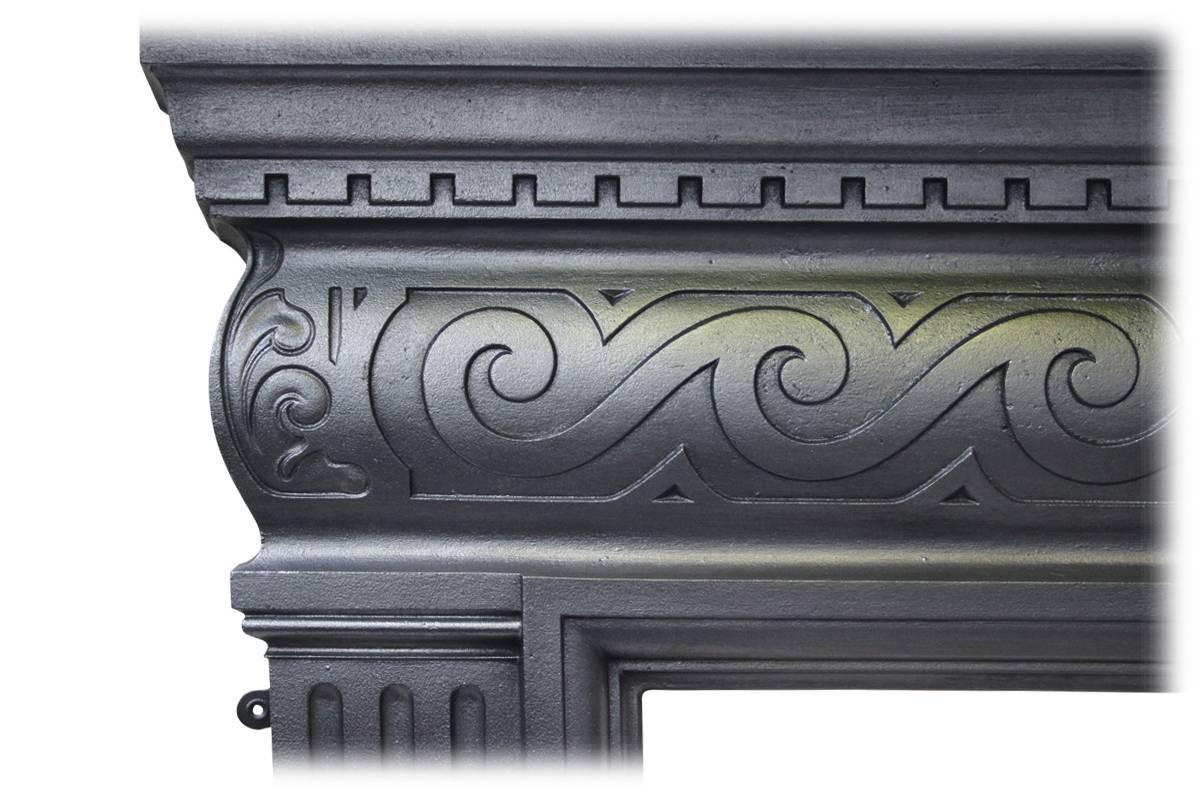 Antique late Victorian cast iron fireplace surround. Below dentil moulding the cushion shaped frieze ins sharply cast with Vitruvian scroll work. The legs benefit from flutes and reeds. Fully restored and finished with traditional black grate