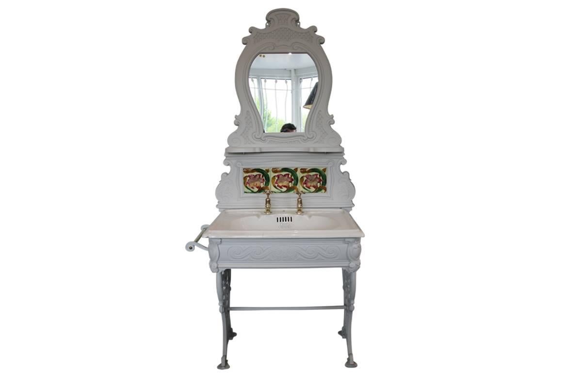Edwardian cast iron wash stand with tiled and mirrored splash-back, complete with original basin, unlacquered taps and brass towel rail which can be positioned either side of the stand, circa 1905. The cast iron has been primed so it can be painted
