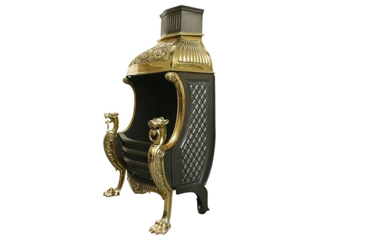 Mid Victorian brass canopied dog grate in the Regency style supported by brass wolfhounds with rings in their mouths and on clawed feet. The decorative cast brass domed canopy vents out of a reeded cast iron flue. We currently have a pair of these
