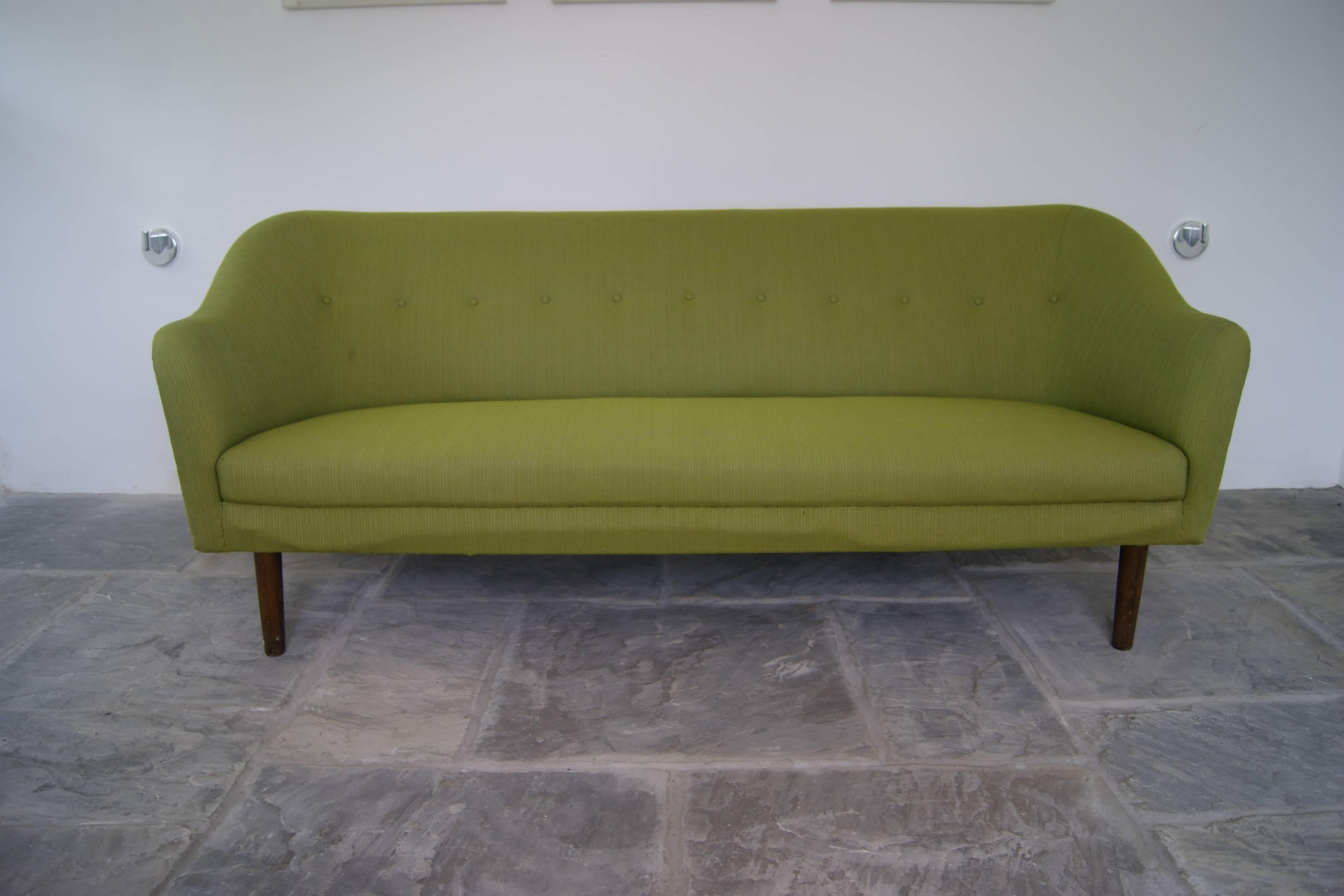 Danish Mid-Century three-seat sofa with curved details, button back detail and dark stained wooden legs. Can be reupholstered on request - charged separately.