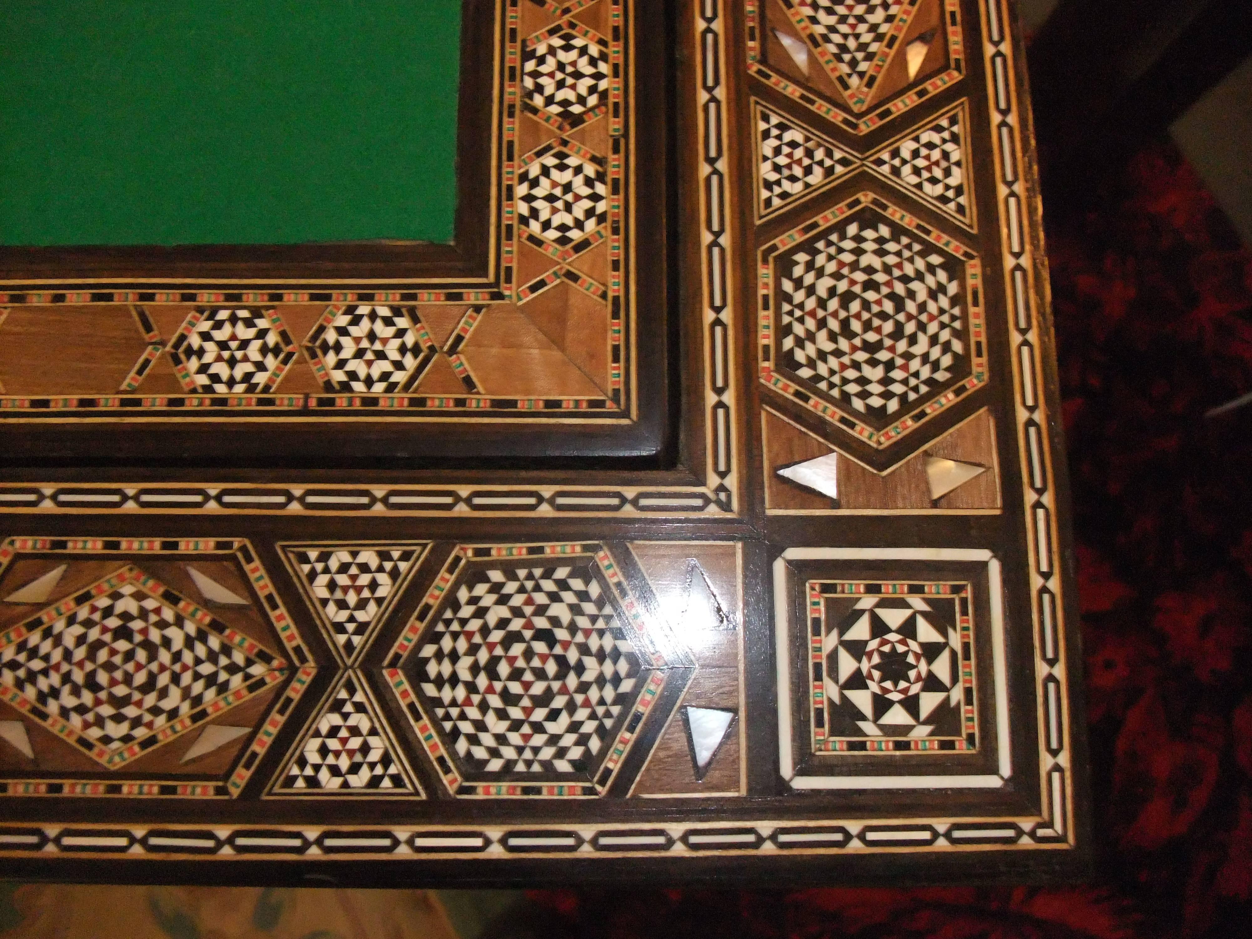 Damascus games table brought back from Syria in 1946. The whole is covered in specimen woods, mother-of-pearl, ivories etc. Small areas of missing embellishment commensurate with age. Measures: 29' x 15' doubling in size to 29' x 29'. £850.
 