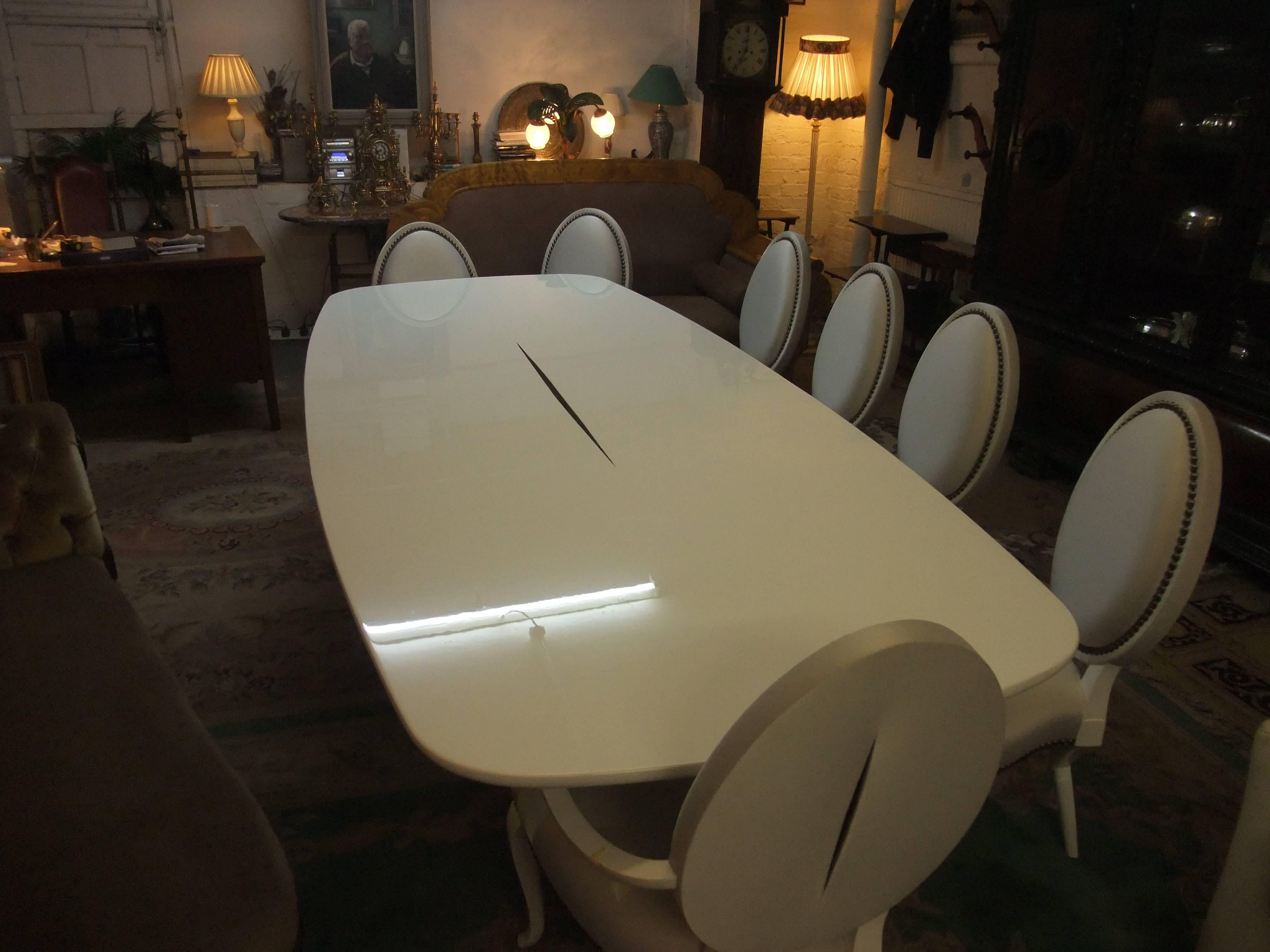 White enamel dining room suite consisting of two carvers, five side chairs, and table, all by Christopher Guy (liquidated stock). Undamaged and ready for assembly. Approximately £22,000 worth of furniture and still in production today. Chairs