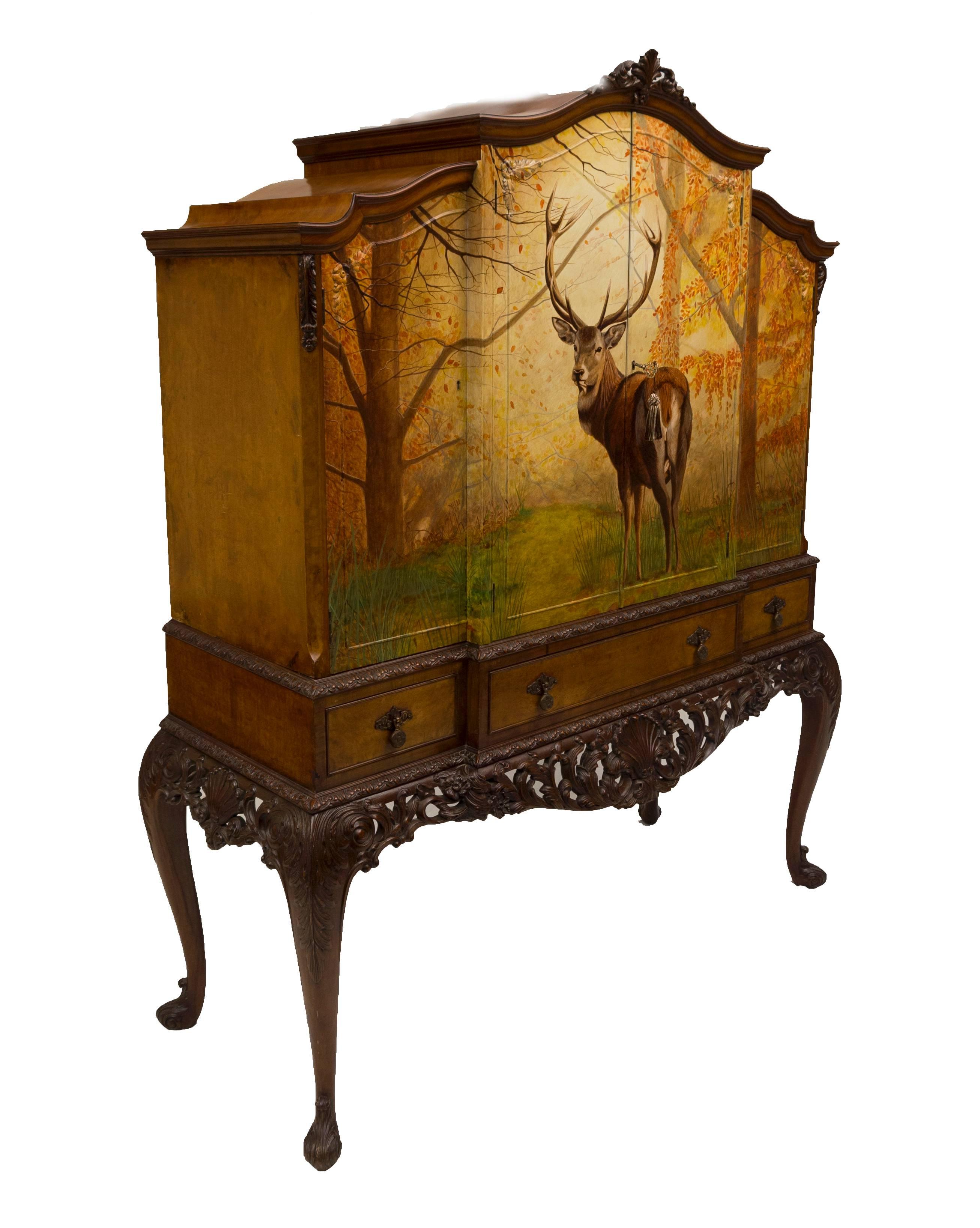 This burr walnut cocktail cabinet is intrinsic in design and appeal. The Majestic Stag in an autumn forest backdrop gracefully adorns this 1920s cabinet. The antique cabinet has been refurbished to a high standard and hand-painted by Kensa Designs.