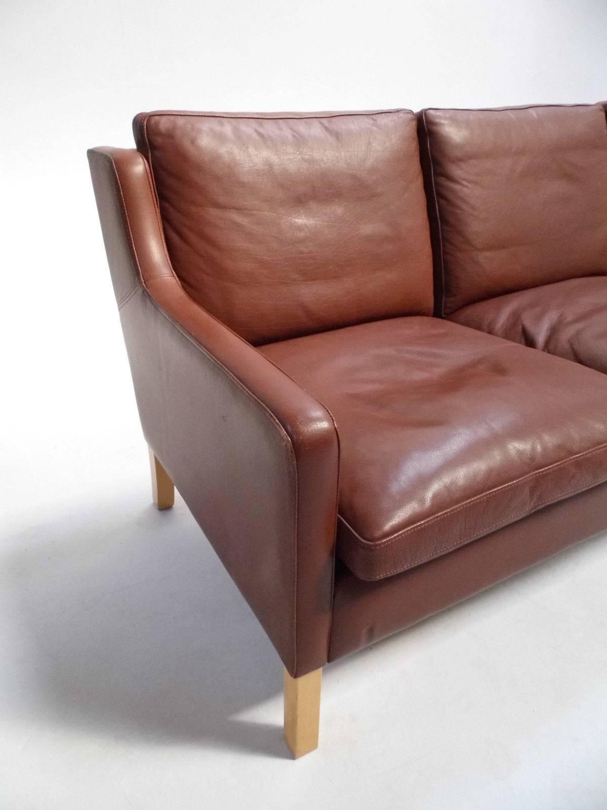 A beautiful Danish brown leather three-seat sofa by Stouby, this would make a stylish addition to any living or work area. The sofa has wide cushions and slim padded armrests for enhanced comfort. A striking piece of Classic Scandinavian