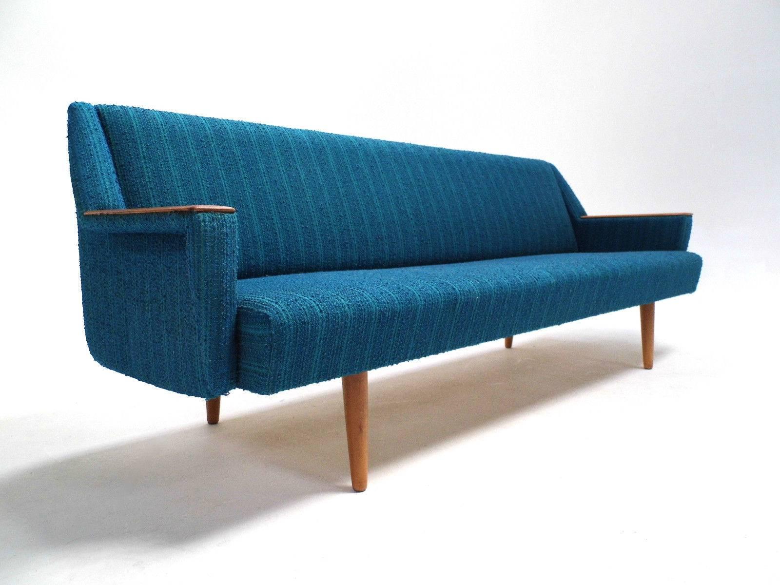 A beautiful Norwegian turquoise blue wool four-seat sofa bed, this would make a stylish addition to any living or bedroom area. The back panel of the sofabed pulls down to create a comfortable double bed. A striking piece of classically designed