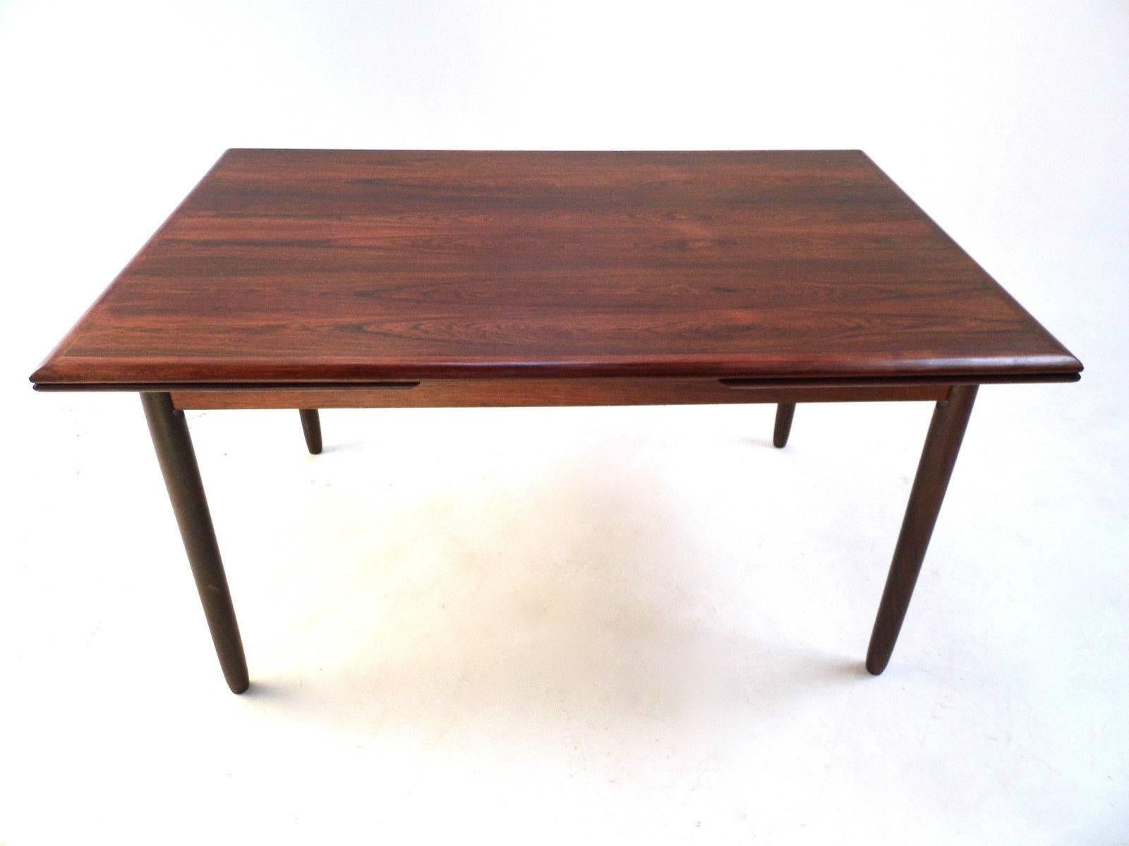 A beautiful Danish rosewood extending dining table, this would make a stylish addition to any dining area. The table has two extension panels which fit discreetly below the top panel and can be pulled out when needed. A striking piece of classically