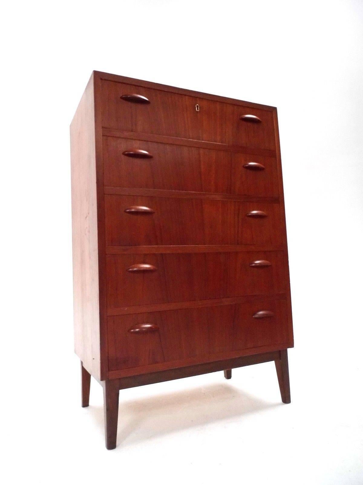 A beautiful Danish teak tallboy chest of drawers, this would make a stylish addition to any bedroom area. The chest has five drawers, all are in good working order with sculptured wooden handles. A striking piece of classically designed Scandinavian