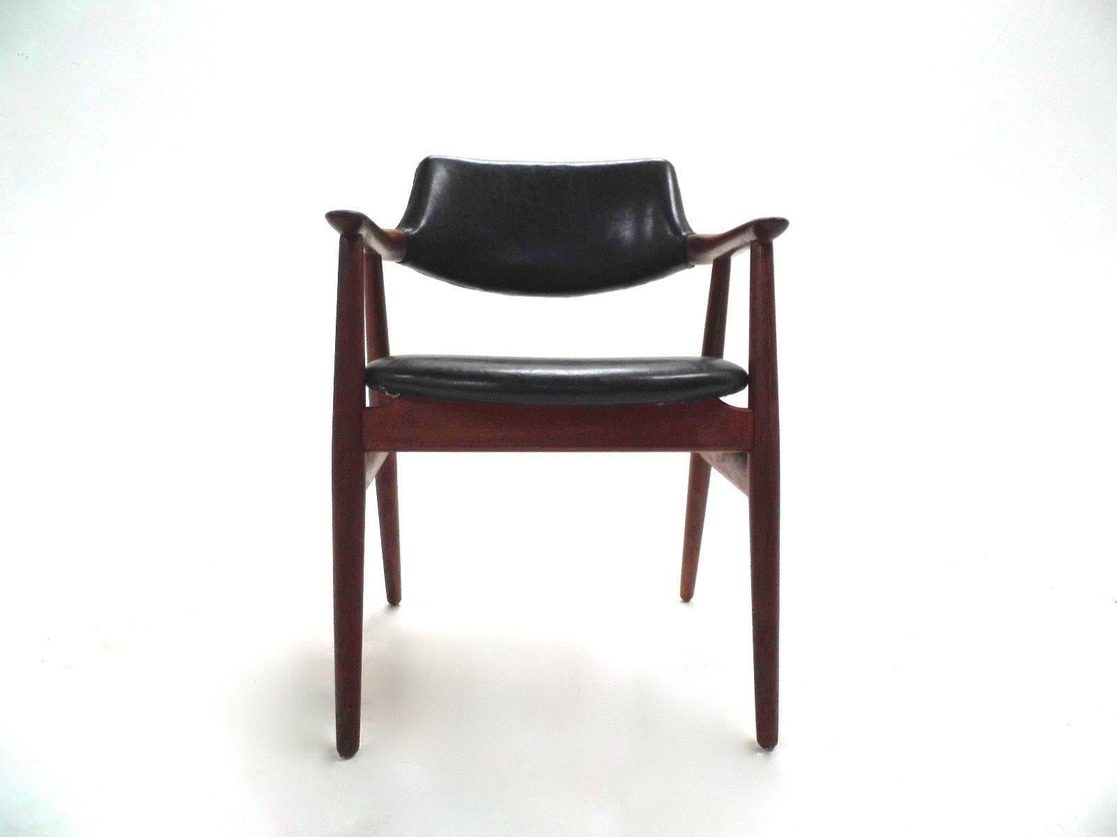 A beautiful teak and soft black vinyl desk chair designed by Svend Åge Eriksen for Glostrup Mobelfabrik in the 1960s, this would make a stylish addition to any living or work area. The chair has a curved backrest and sculptured teak armrests for