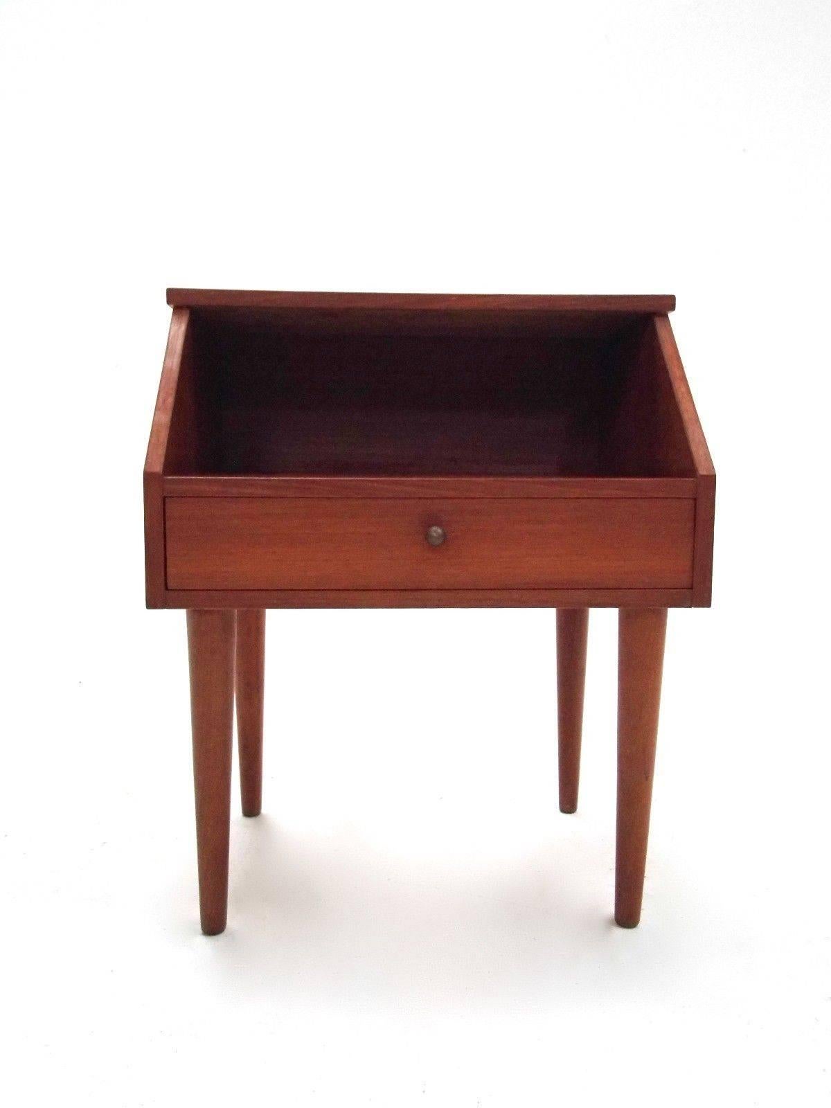 A beautiful set of Danish teak bedside cabinets, these would make a stylish addition to any living or bedroom area. The cabinets have a storage compartment to the top and a slim drawer with brass handle below. A striking piece of classically