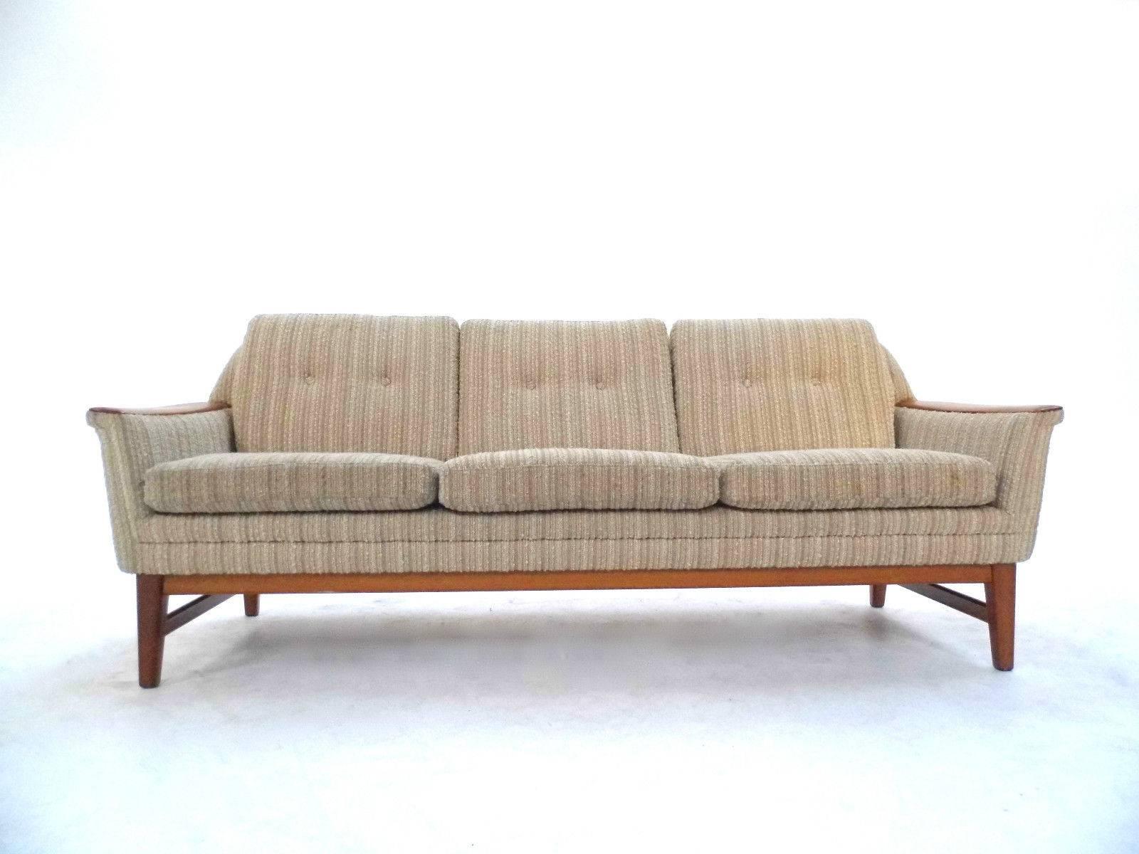 A beautiful Norwegian cream wool three-seat sofa, this would make a stylish addition to any living or work area. The sofa has a buttoned backrest and sculptured teak arms for enhanced comfort. A striking piece of classically designed Scandinavian