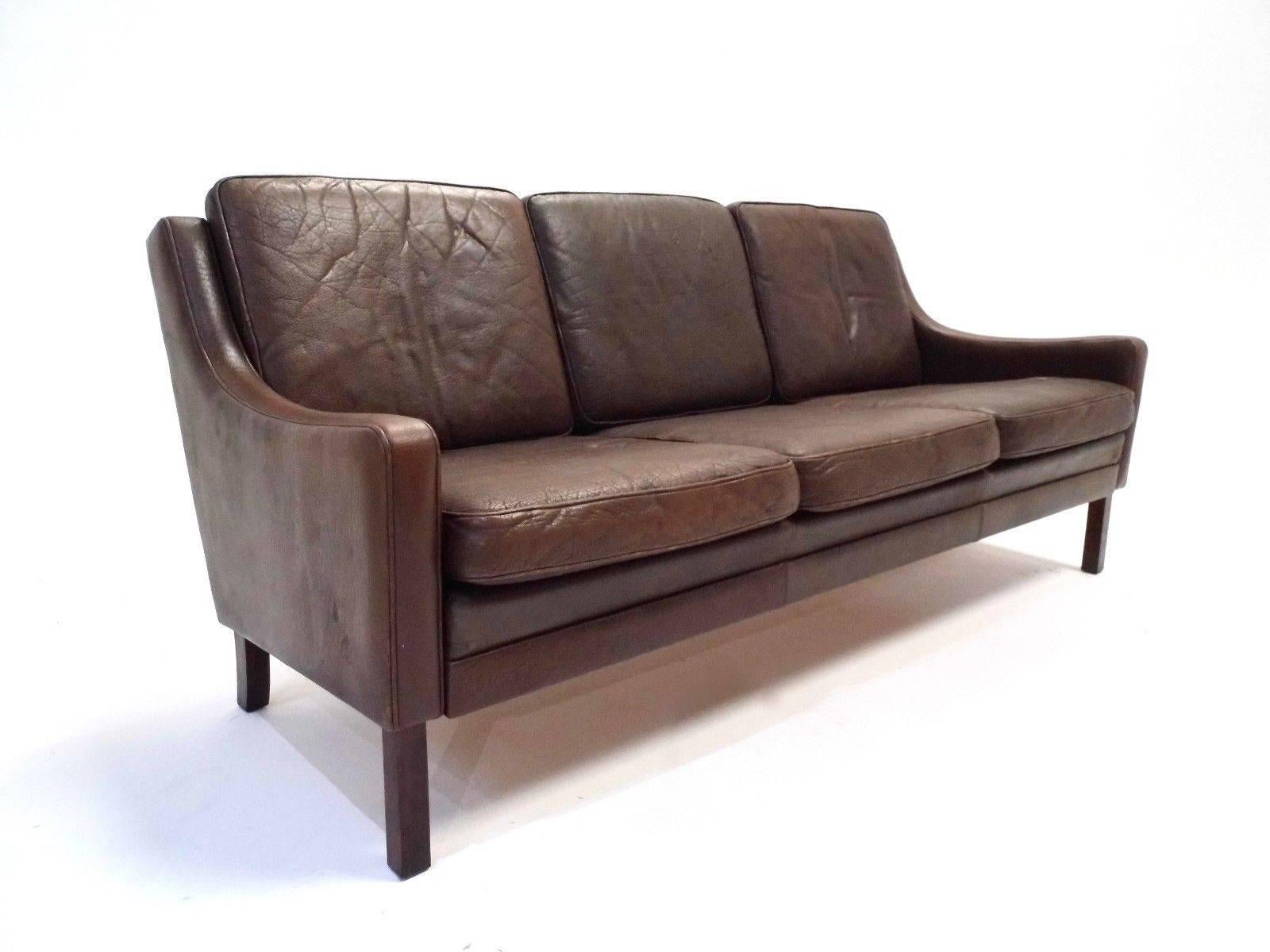 A beautiful Danish dark brown leather three-seat sofa, this would make a stylish addition to any living or work area. The sofa has wide cushions and padded armrests for enhanced comfort. A striking piece of Classic Scandinavian furniture.

The