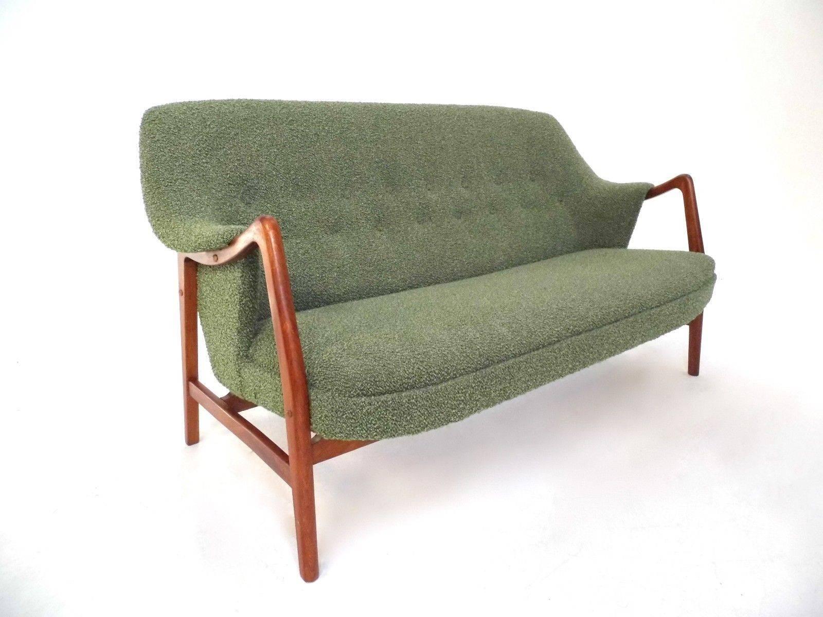 A beautiful Danish 'Rio' green wool and teak three-seat sofa by Dokka Mobler, this would make a stylish addition to any living or work area. The sofa has a curved backrest and sculptured teak arms for enhanced comfort. A striking piece of