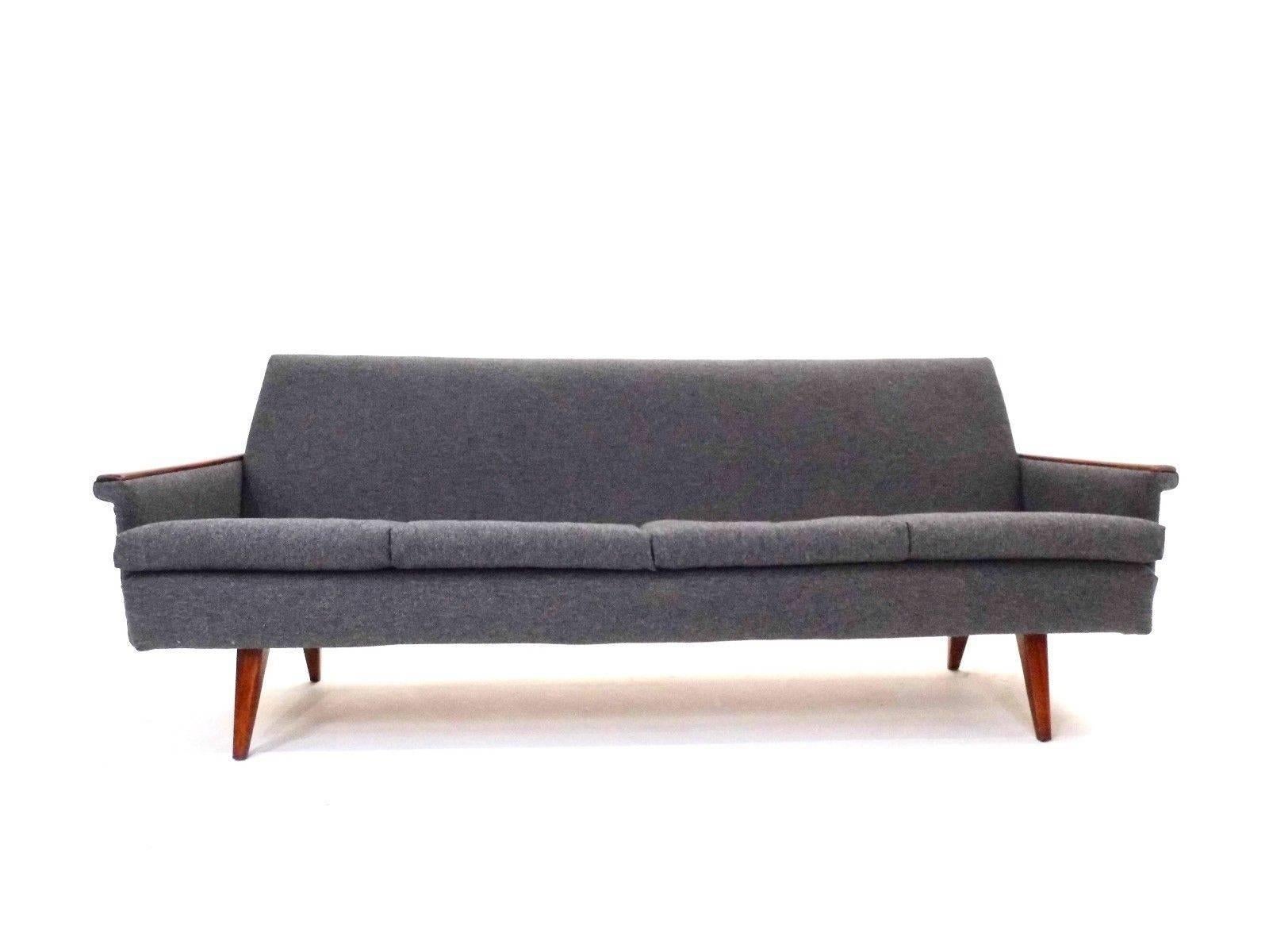 A beautiful Norwegian dark grey wool and teak three-seat sofa, this would make a stylish addition to any living or work area. The sofa has a high padded back and sculptured armrests for enhanced comfort. A striking piece of Classic Scandinavian