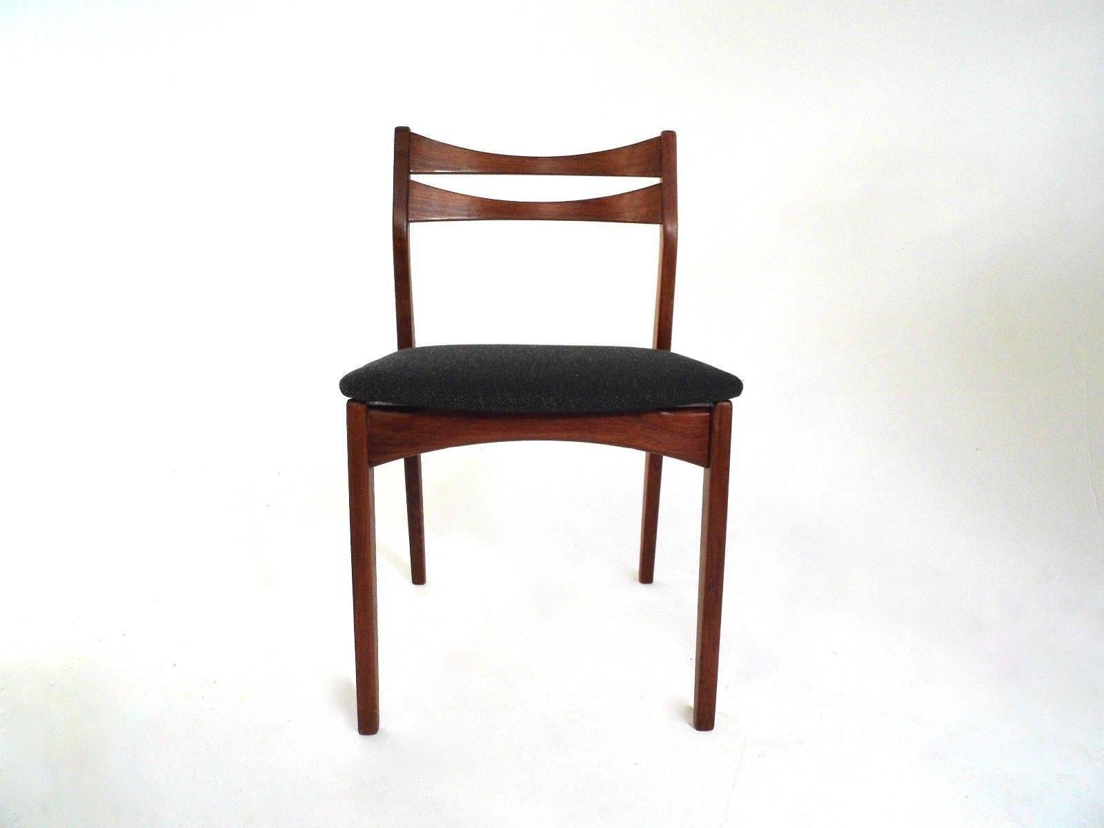 A beautiful set of four Danish teak and grey fabric dining chairs; these would make a stylish addition to any dining area. The chairs have wide seat pads and sculptured teak back rests. A striking piece of classically designed Scandinavian