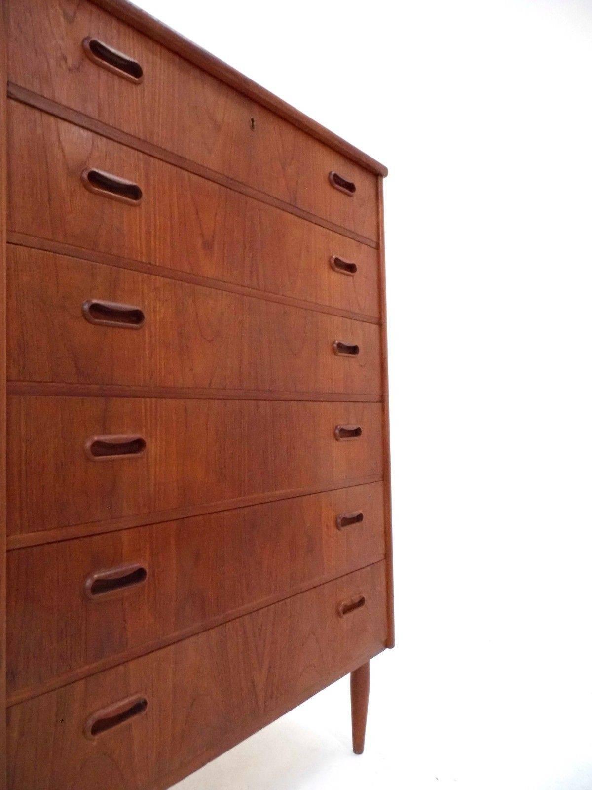 A beautiful Danish teak tallboy chest of drawers, this would make a stylish addition to any bedroom area. The chest has six drawers, all are in good working order with sculptured wooden handles and dovetail joins. A striking piece of classically