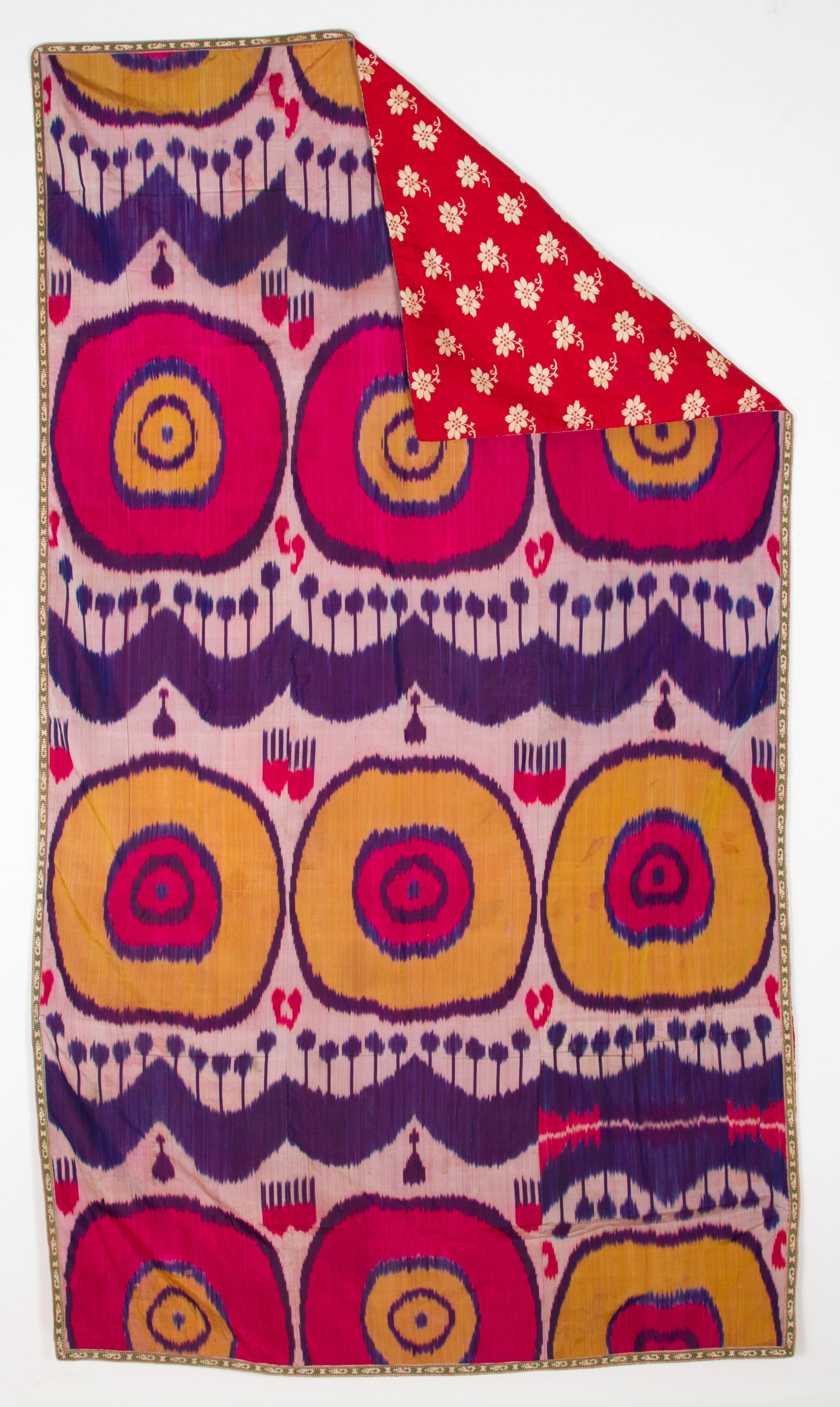19th century antique silk Ikat throw, this Ikat design from the 19th century has vibrant pink, purple and yellow design on off-white background with red cotton backing and embroidered edging. This piece could look like a modern pop art