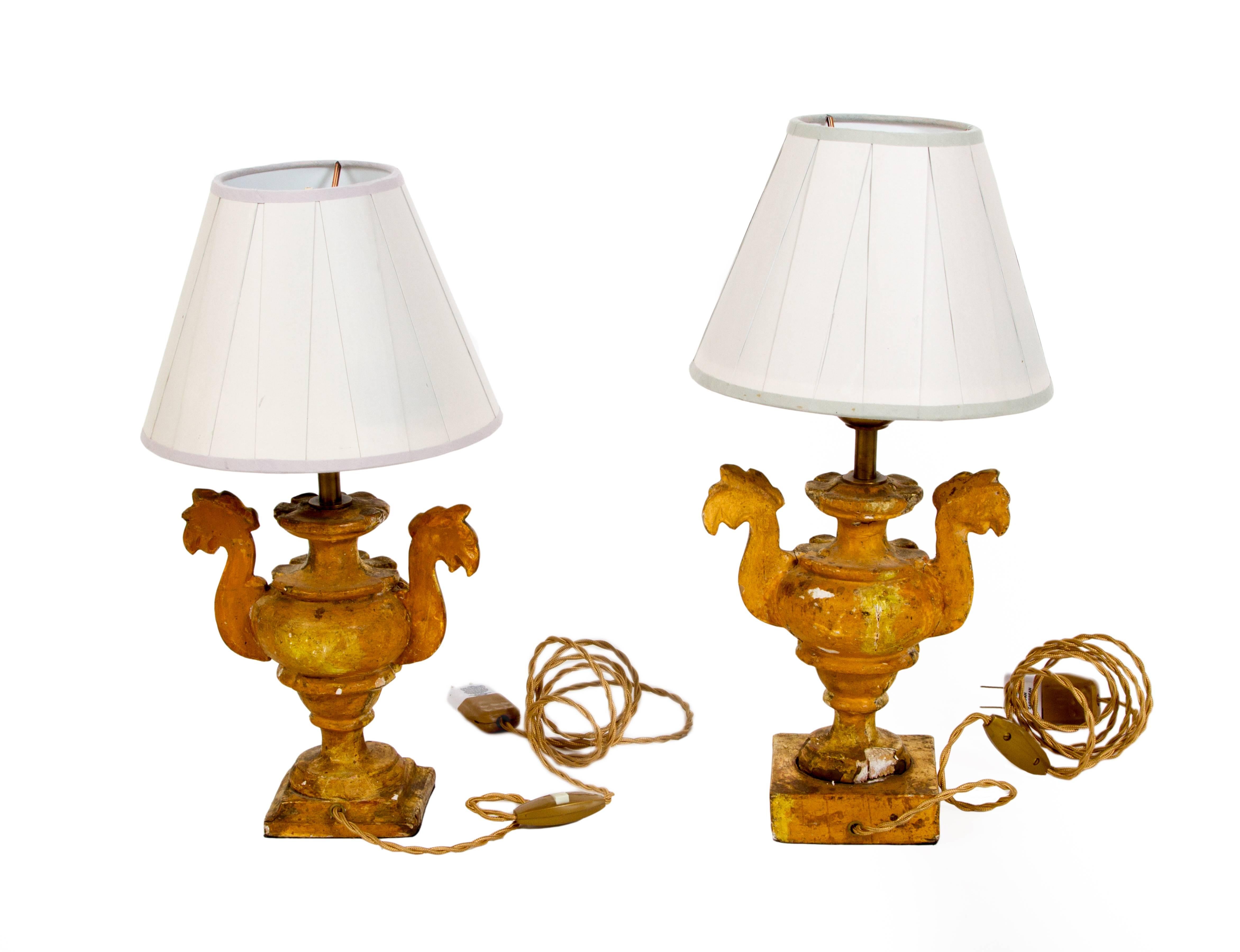19th century pair of painted and parcel giltwood lamps from Tuscany.
Most likely made into lamps from altarsticks. One side is painted in yellow gold and the other side is gilded, which would have faced out towards the congregation.
Paper shades