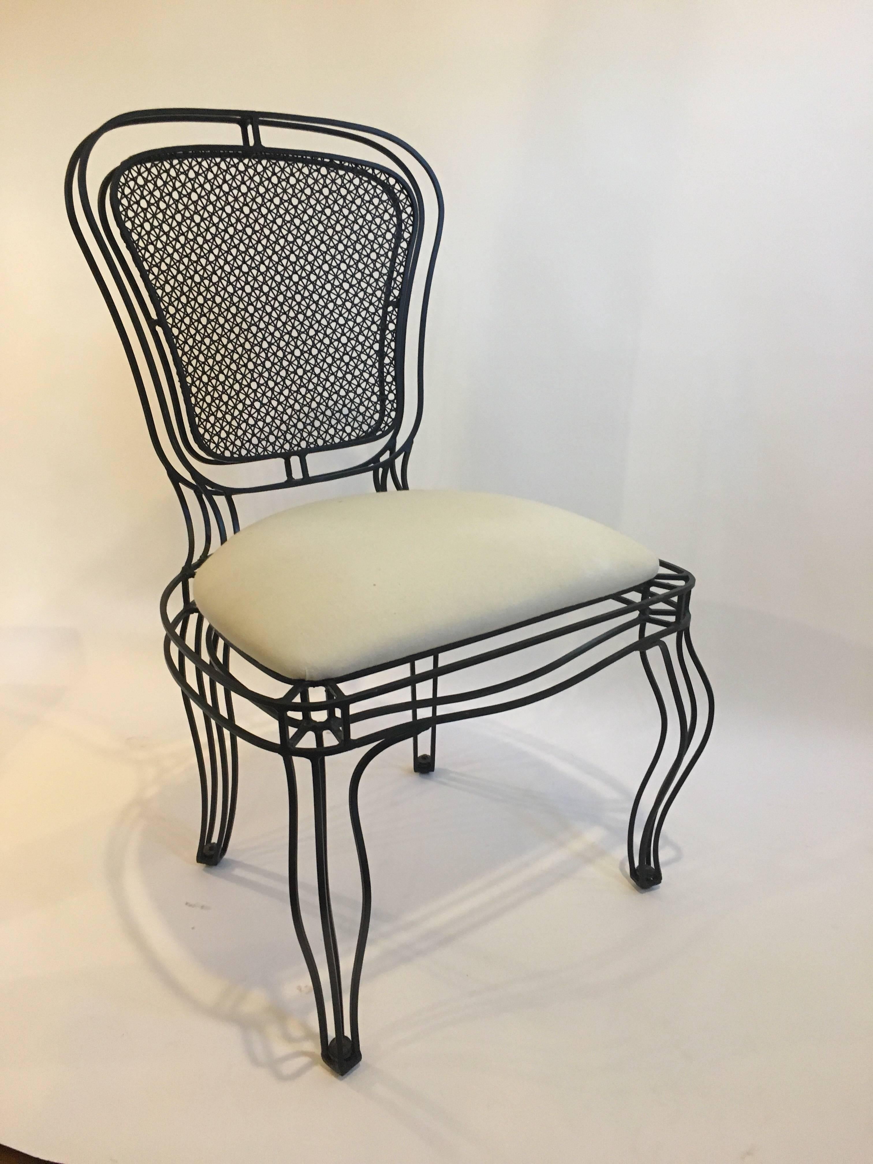 Chaises Manchez en fer noir Casamidy recouvertes de tissu mousseline. Ces chaises peuvent être utilisées à l'intérieur ou à l'extérieur avec le tissu d'extérieur approprié. Ces chaises modernes, épurées, de style français, sont solides mais