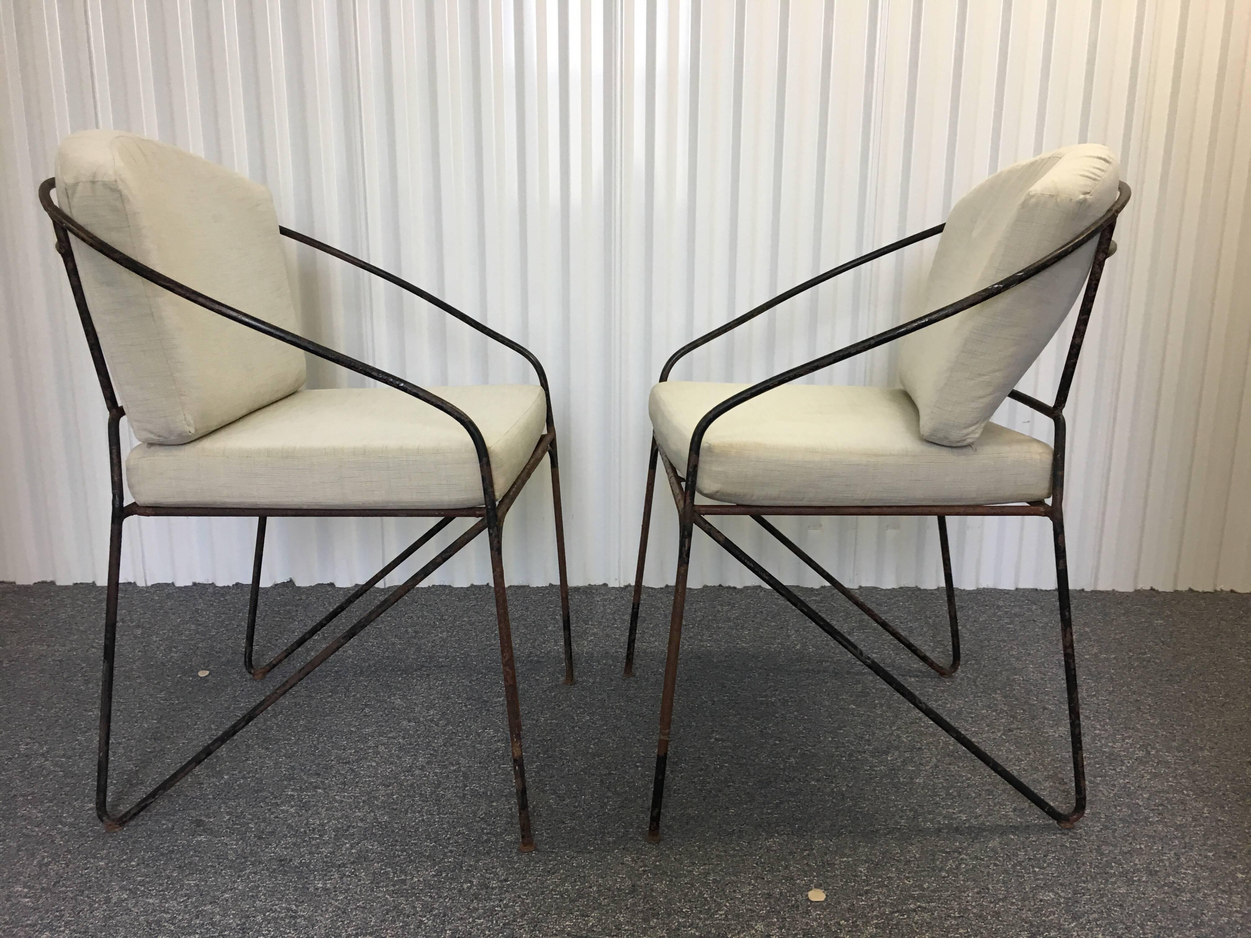 Pair of 19th c. French Iron Armchairs with a lovely rounded back.  Custom made cushions for rounded back.  Rusted black iron patination on surface of chairs. Cushion fabric needs refreshing but could be used as is as well. These are quite a