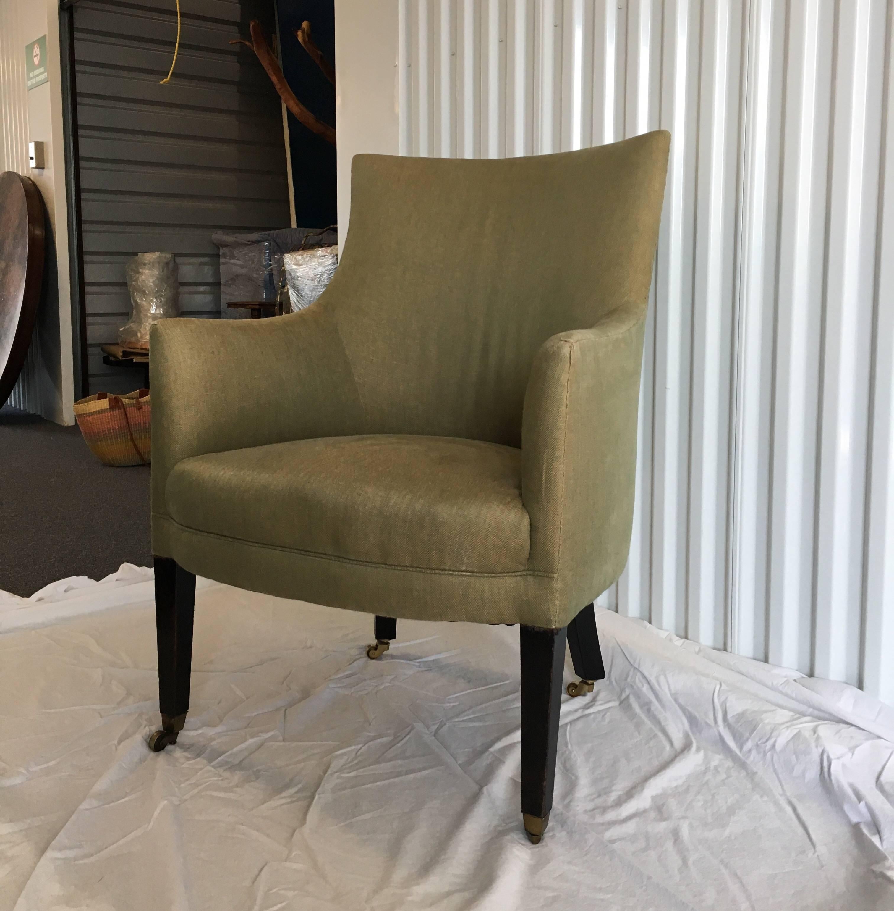 Upholstered English Library chair withbrass casters in green woven herringbone fabric.
 