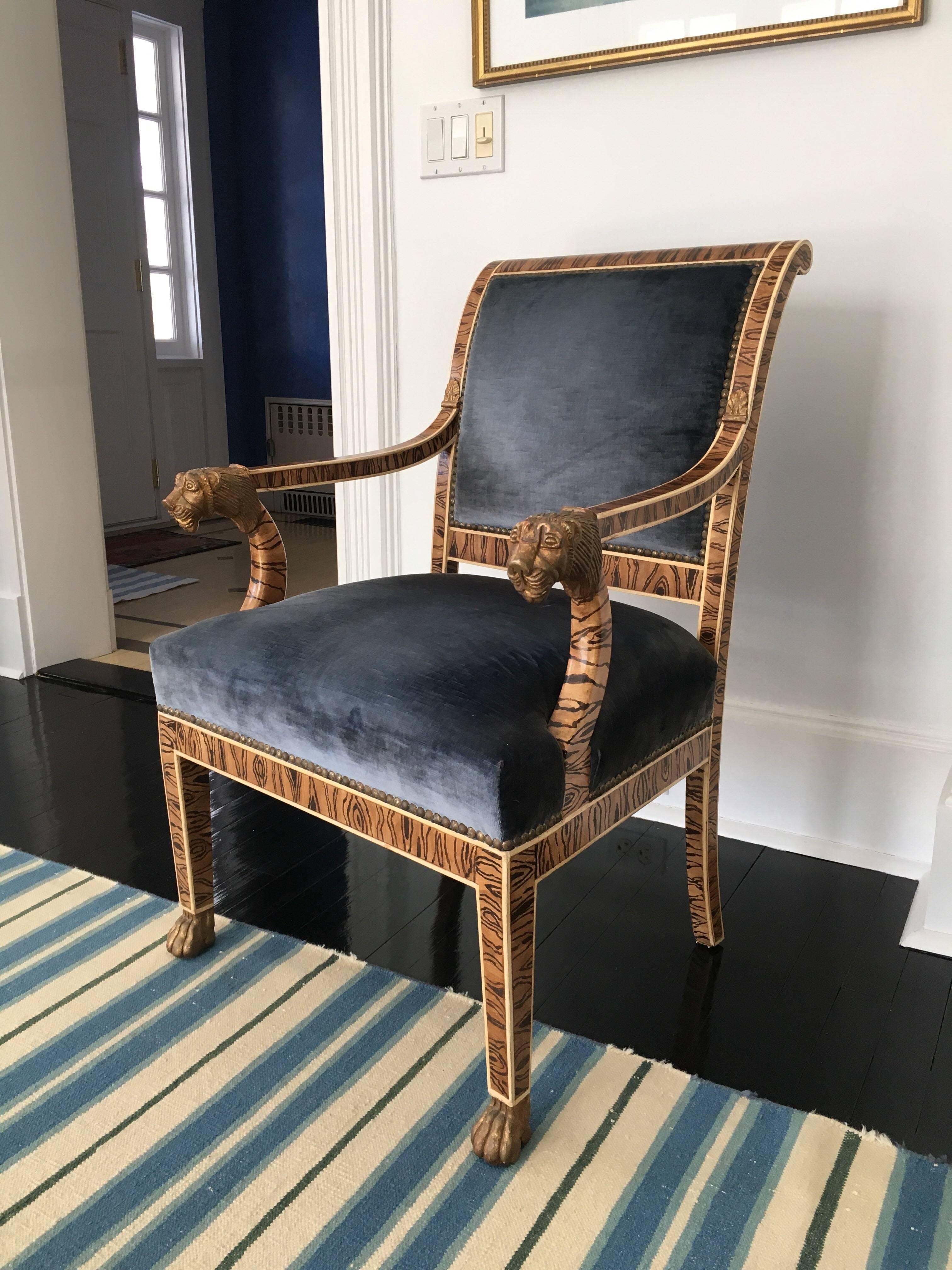 This French Empire Style Upholstered Faux Bois Armchair with Gilded Lion head and paw on arms and legs was custom made by, once top upholster in NYC, Delta Upholsterers. Upholstered in a slate blue silk velvet with brass nail heads around perimeter.