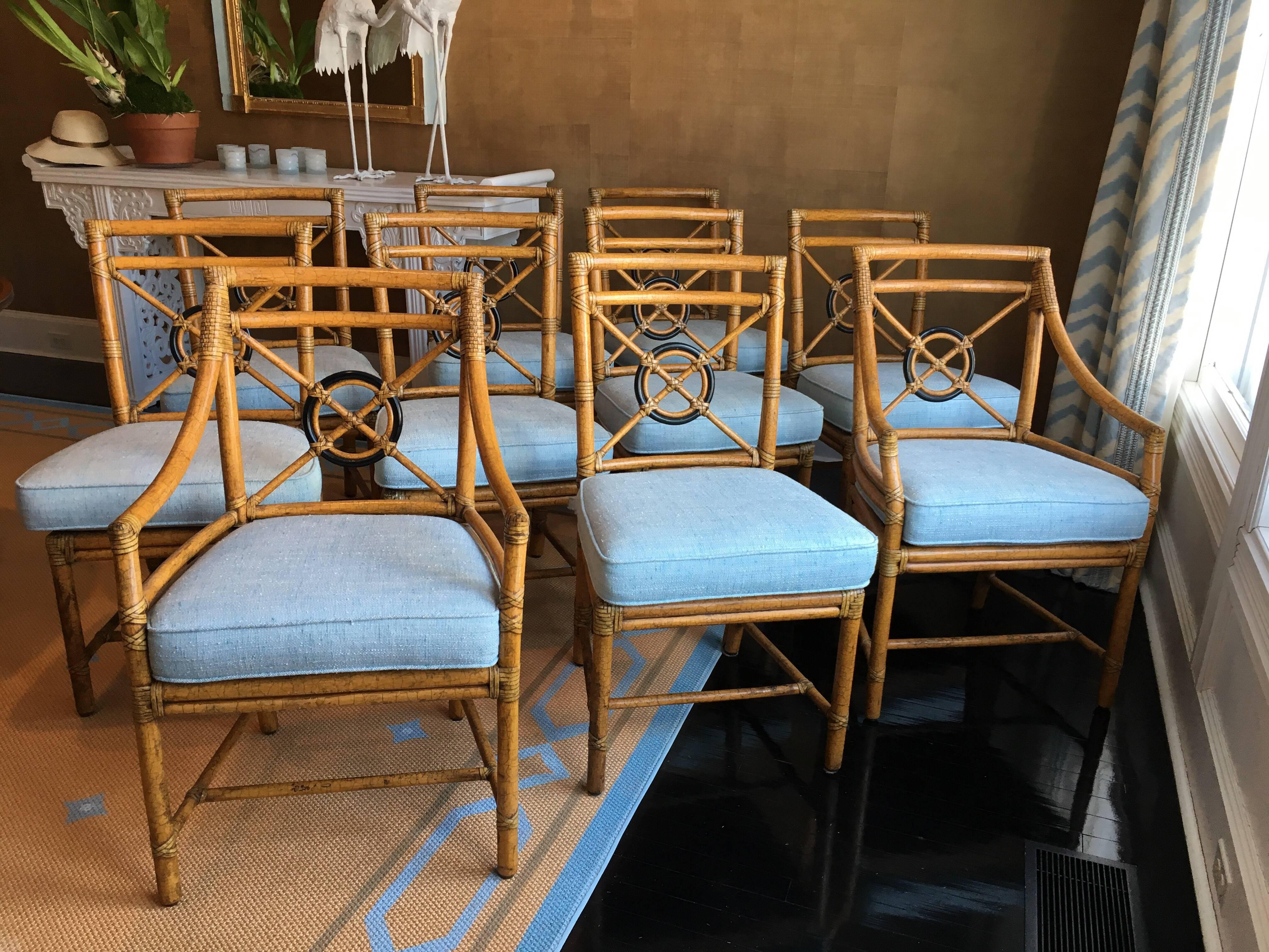 Set of ten 'Target' rattan dining chairs by McGuire.
Eight side chairs, two armchairs in pale blue/white woven textured seat cushions. Chair finish in crackled natural finish. Chair and cushions are in excellent condition, ready for