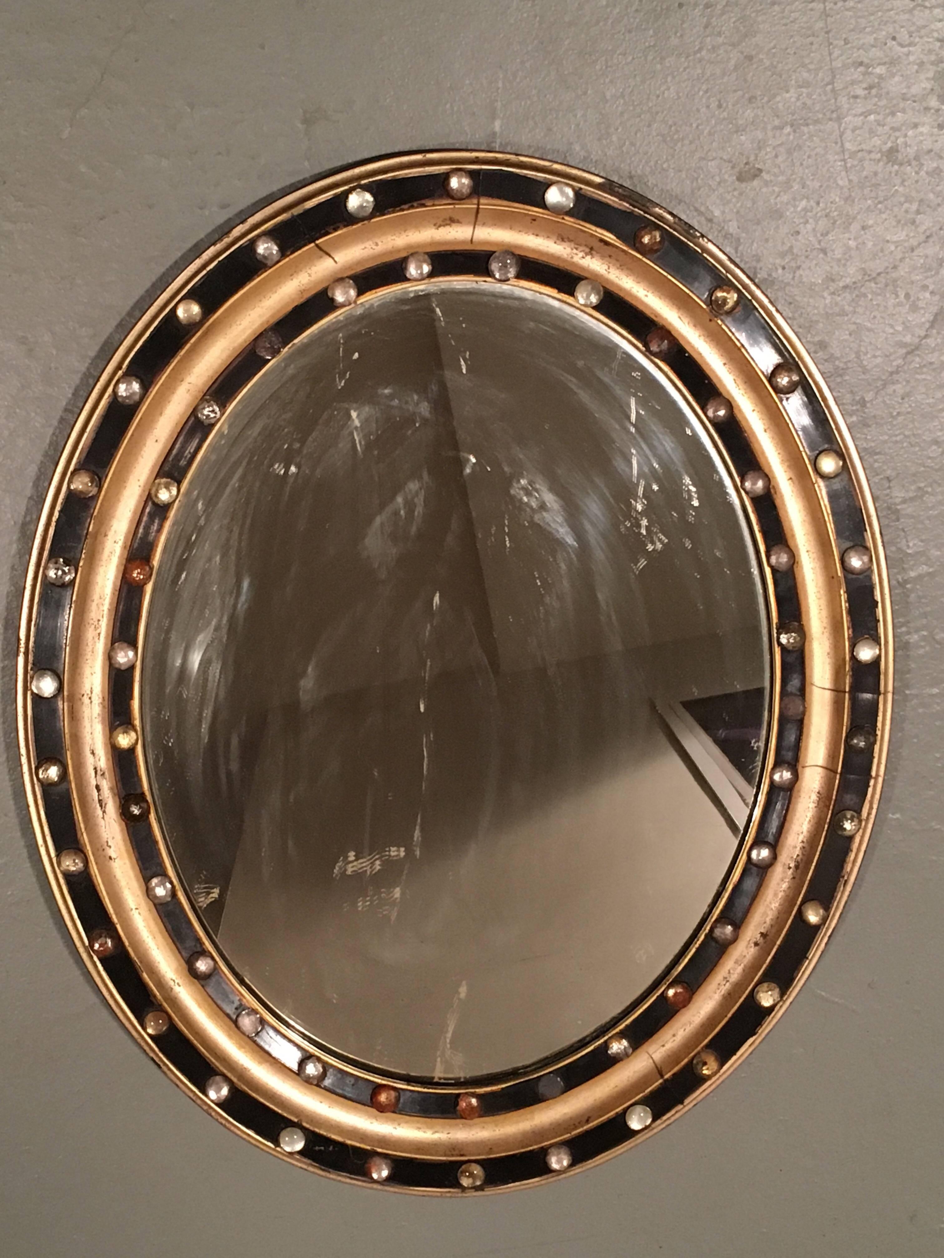 Regency Style oval mirror with faceted glass studs, circa 1890
Parcel-gilt and black paint with faceted glass studs. Some studs missing.

 