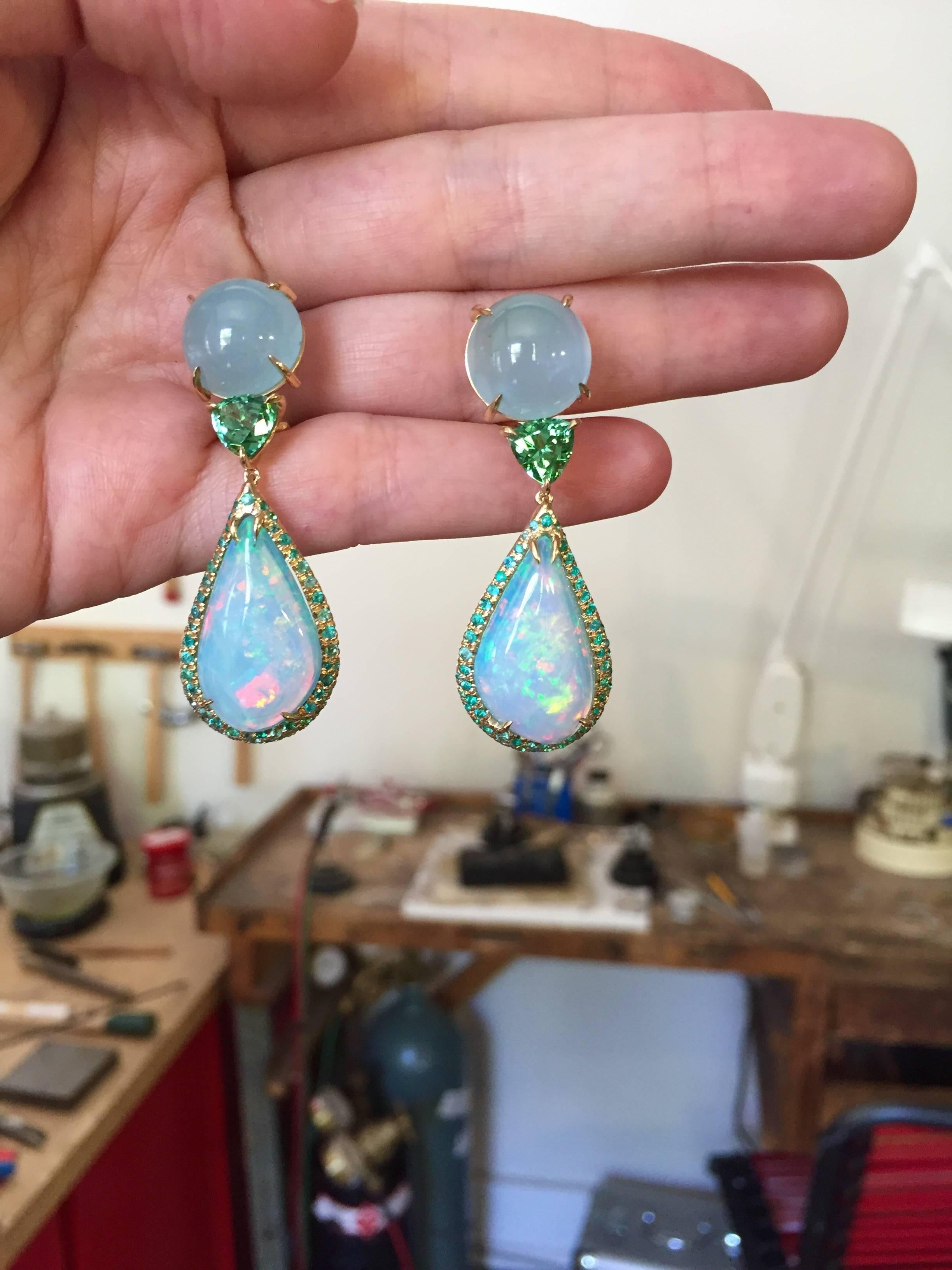 These magnificent earrings will turn every head in the room. Luminous aquamarine cabochons and faceted mint green tourmaline trillions from Mozambique suspend once-in-a-lifetime, semi-translucent, fiery Mexican blue opals surrounded by a medley of