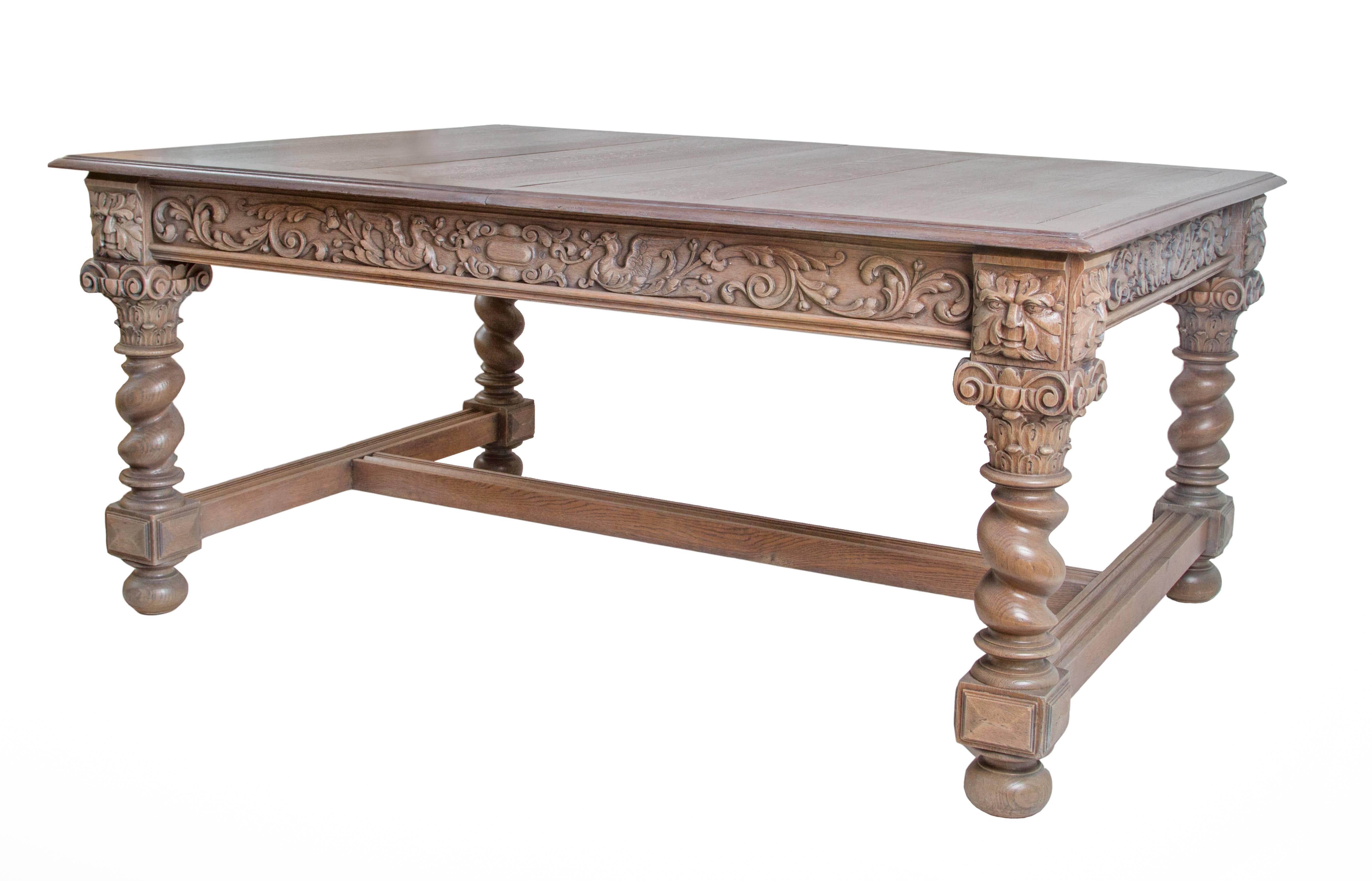 19th century Renaissance Revival carved oak dining table. Made of solid oak, heavily carved with scrolling acanthus leaves on either side of central medallion. Robust turned legs with gem and bun feet and central H-stretcher.

This table has the