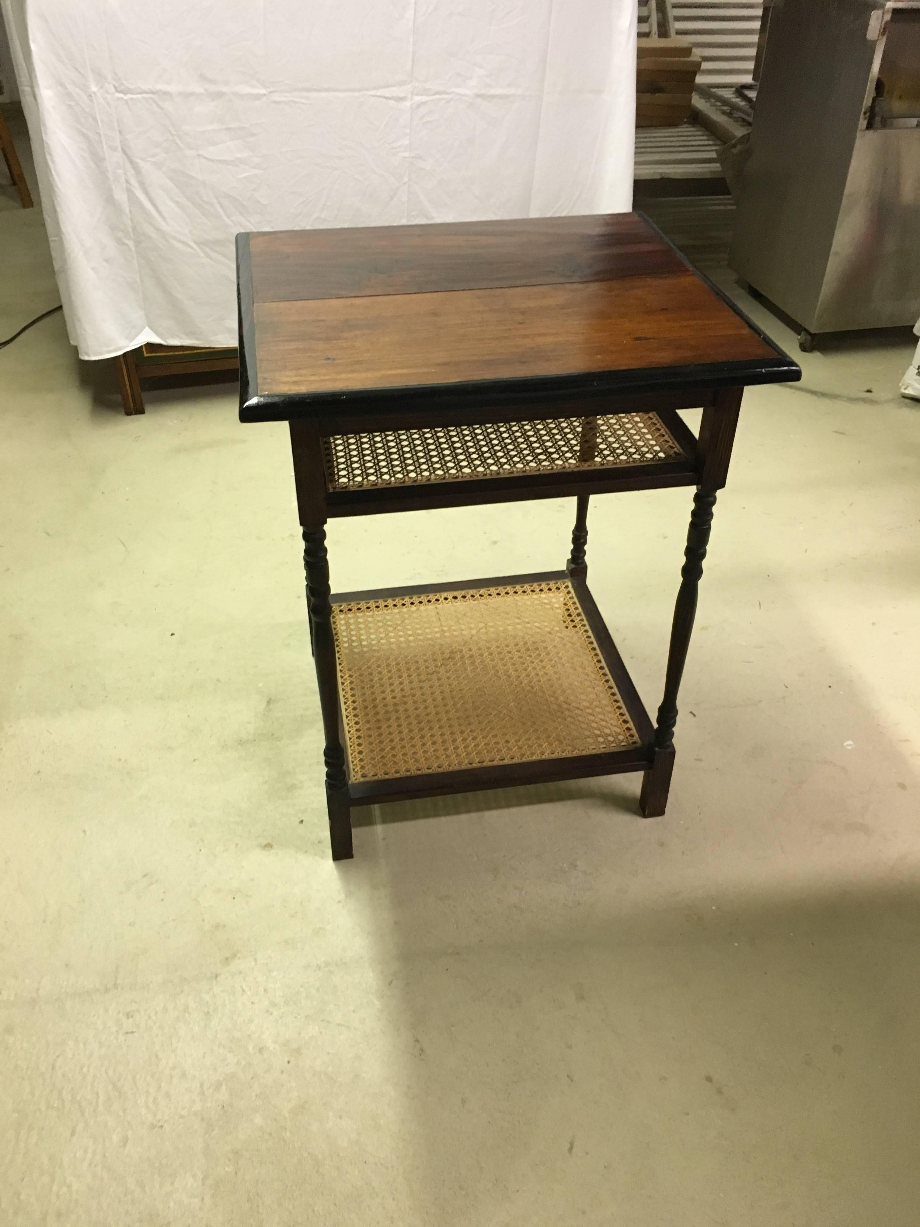 British mahogany and ebony newspaper/magazine table with caned shelves. 

Originally from Hill Country Station for the British Officers, in Nwara Eliya, Sri Lanka.  The little shelf, at the top, held the most current newspaper or magazine and the
