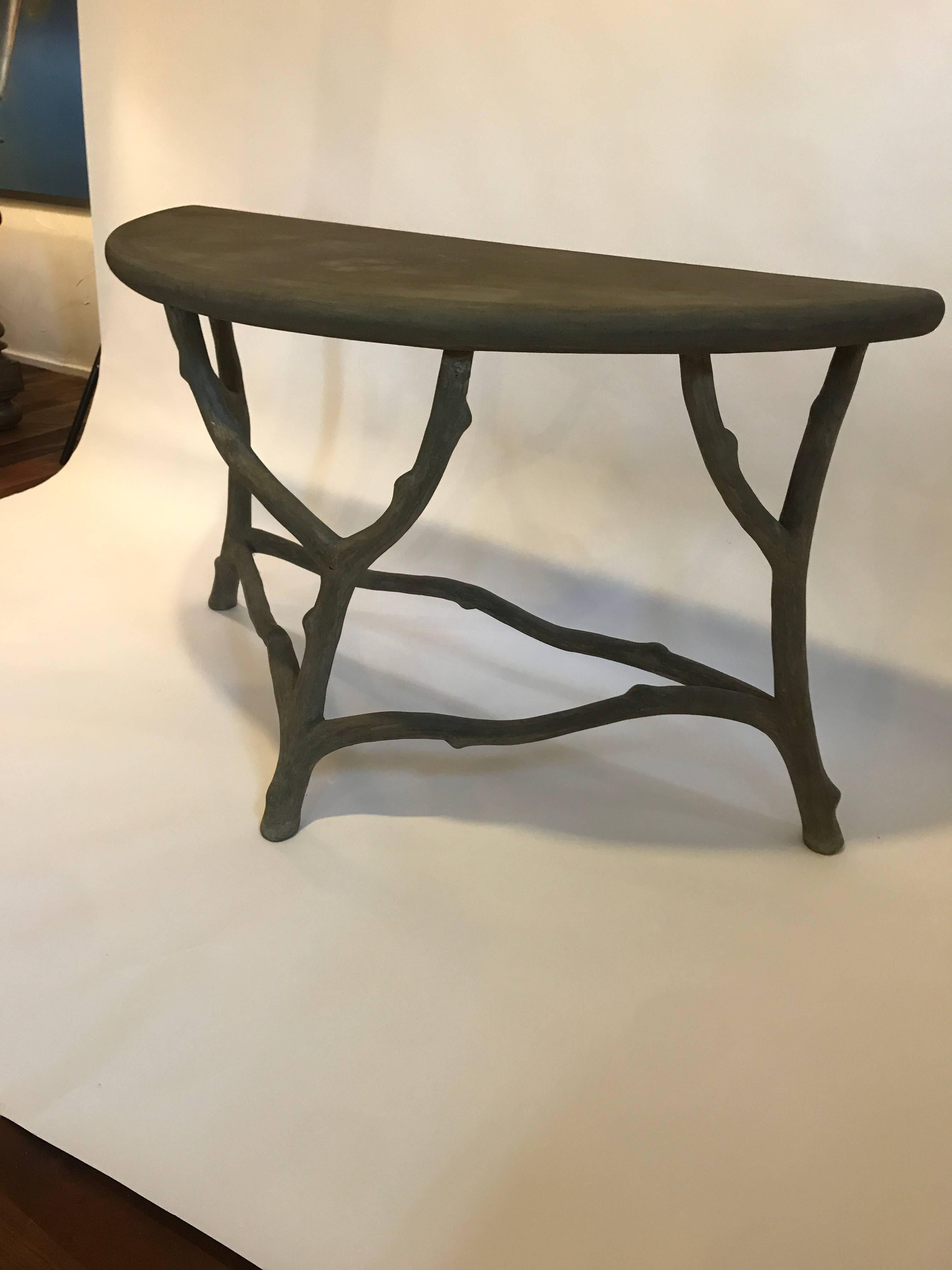 Faux Bois concrete demilune console table
Concrete over metal mesh frame
The first photo reads a bit dark, it is a grey color.
weight: 75 lbs

Top has some water marks and naturally occurring discoloration. Some hairline cracks in the concrete