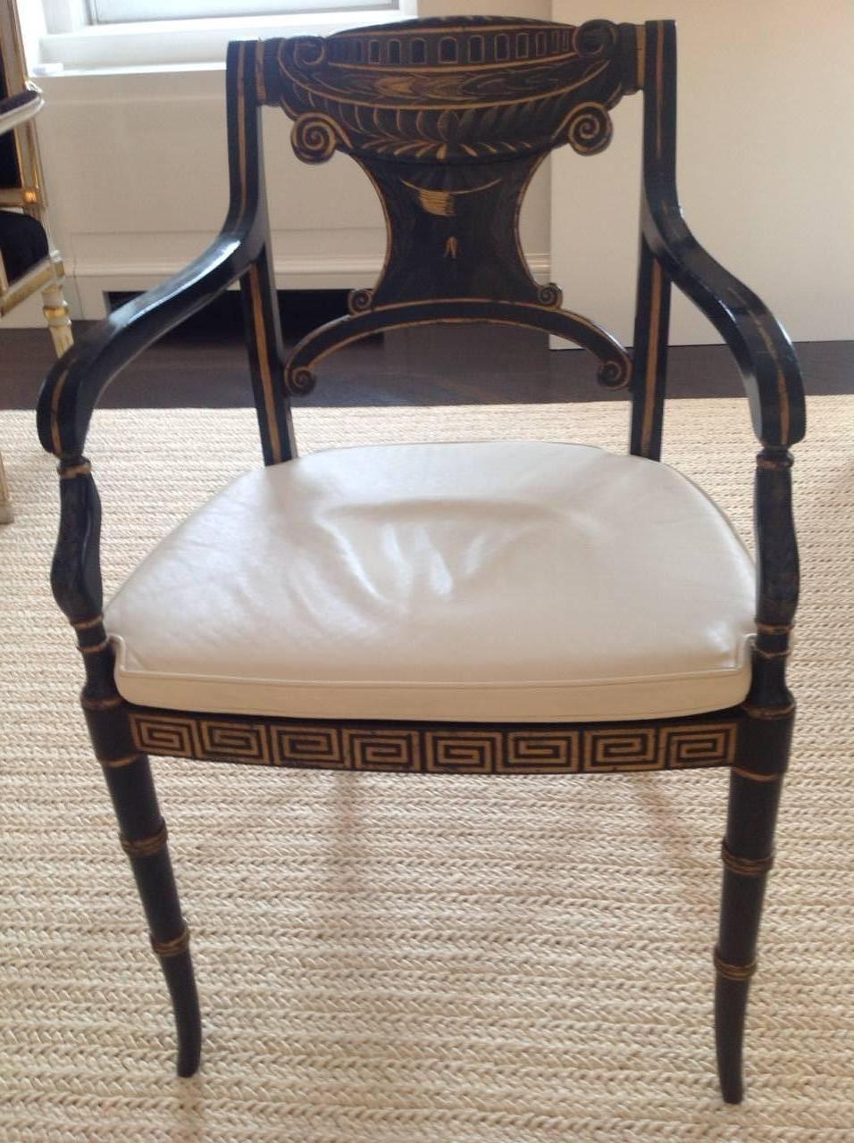 Set of ten Regency style parcel-gilt black painted caned armchairs. Custom cushions fabricated in off white leather in excellent condition. Chairs purchased in 1984 from Kentshire Galleries. Caning damaged on three chairs otherwise in excellent