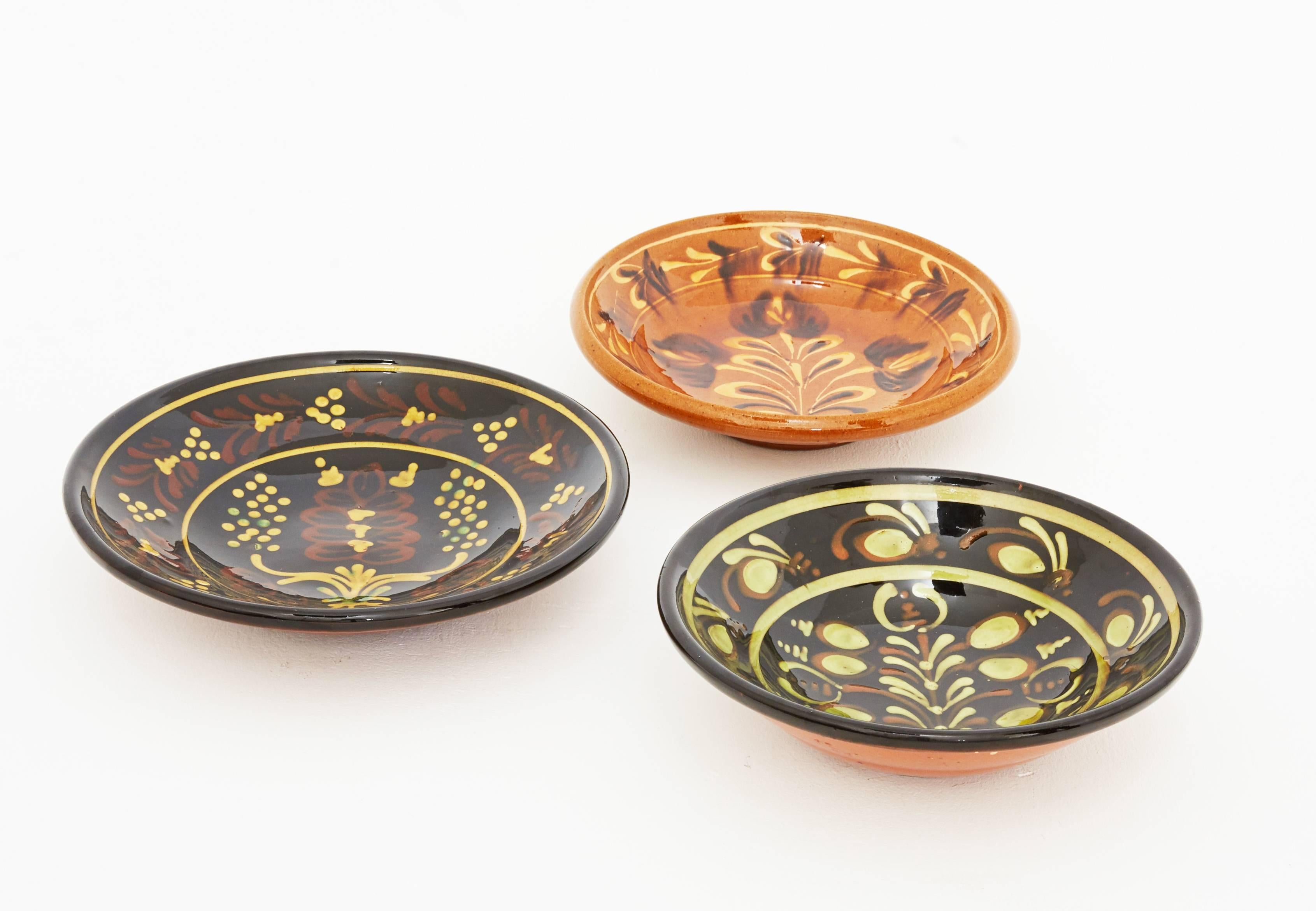 Set of three vintage Hungarian hand-painted plates. These three bowls have a typical decorative motif of the Eastern European terracotta craft tradition. They are glazed and hand-painted and in immaculate conditions. They can be used as serving