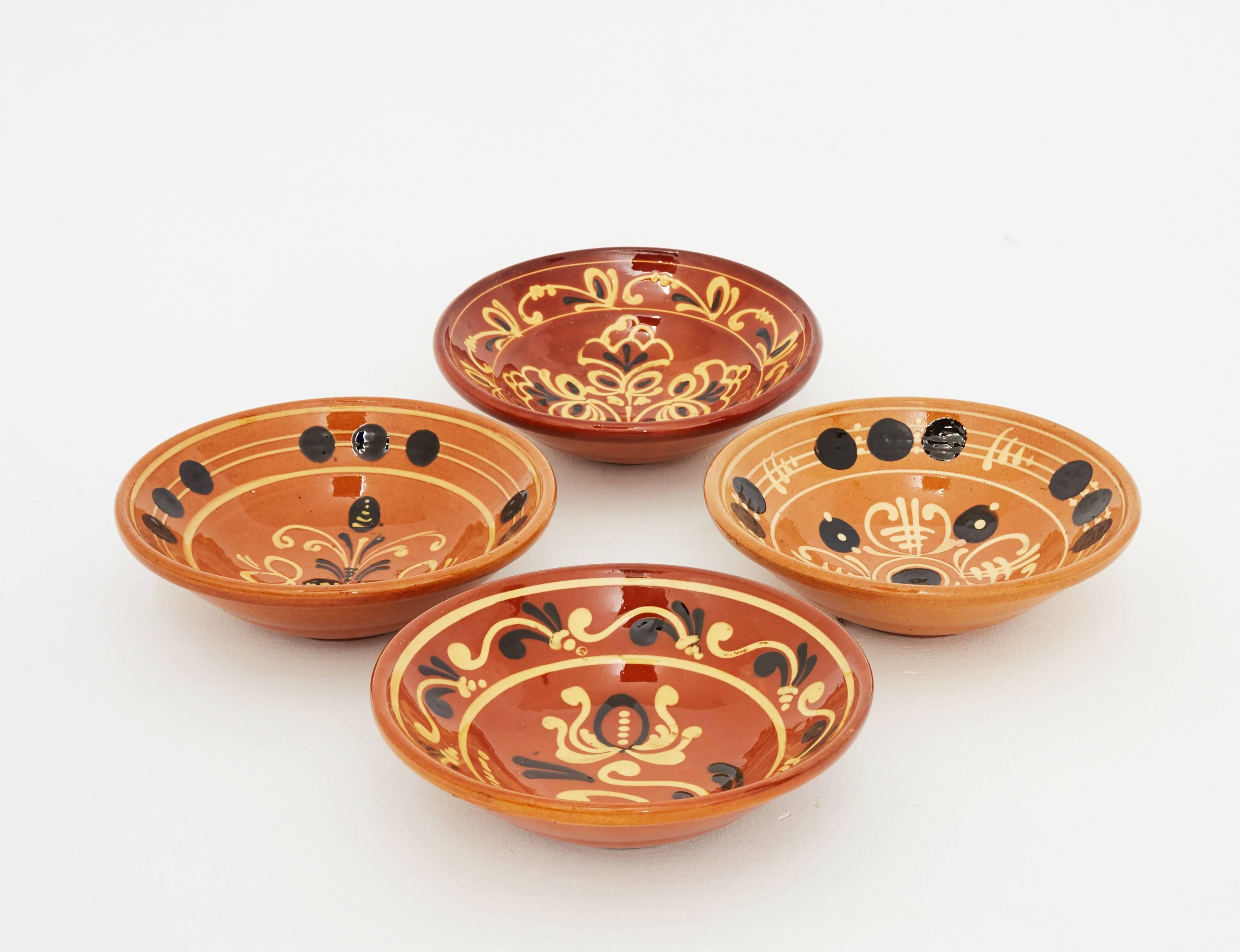 Set of four vintage Hungarian hand-painted plates. These four bowls have a typical decorative motif of the Eastern European terracotta craft tradition. They are glazed and hand-painted and in immaculate conditions. They can be used as serving