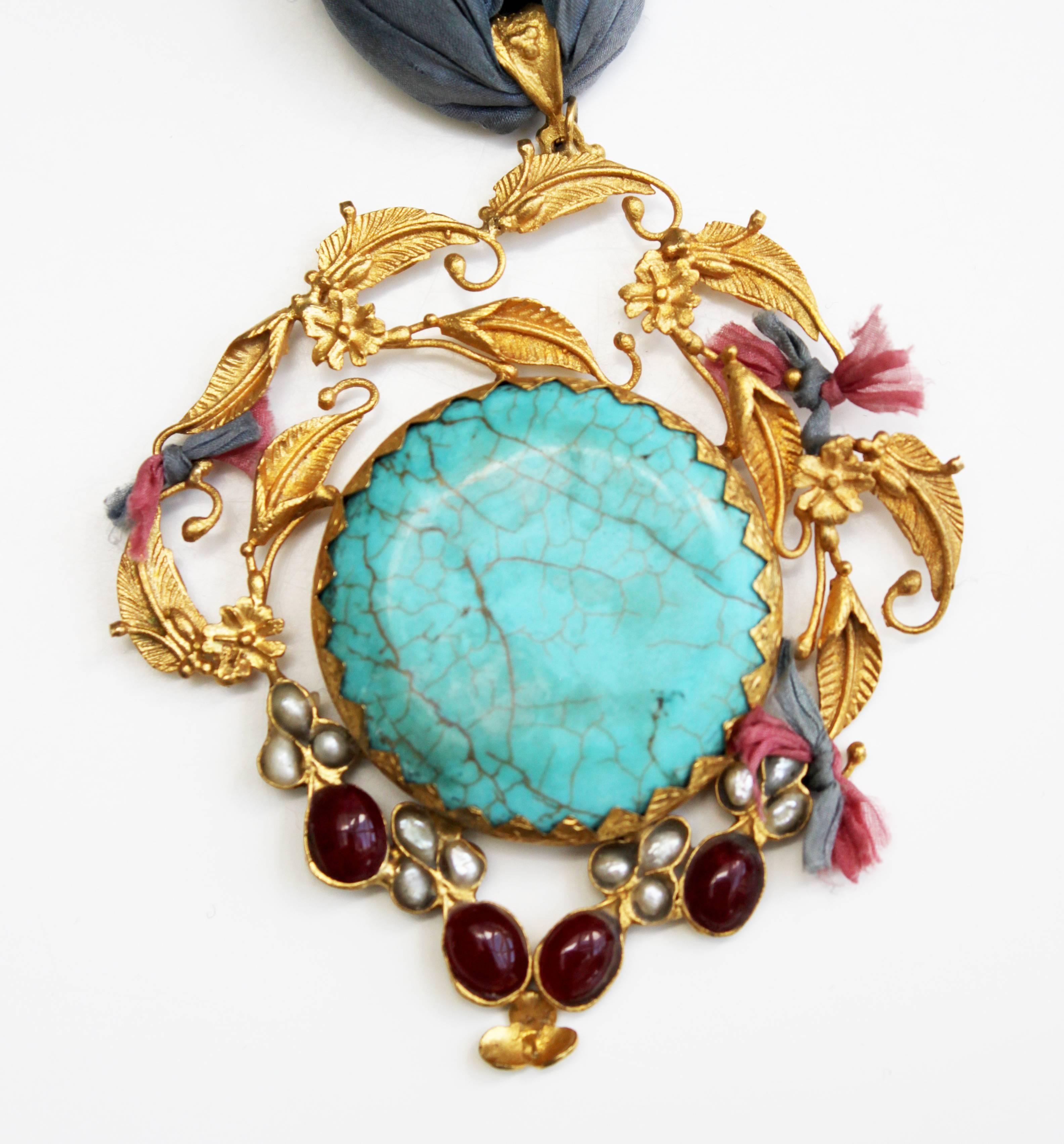 Unique gold-plated pendant with precious stones from Afghanistan. This unique handmade gold-plated pendant was made in Afghanistan, it comes with beautiful mixed precious stones and pearls on long indigo silk necklace. 

The total length of the