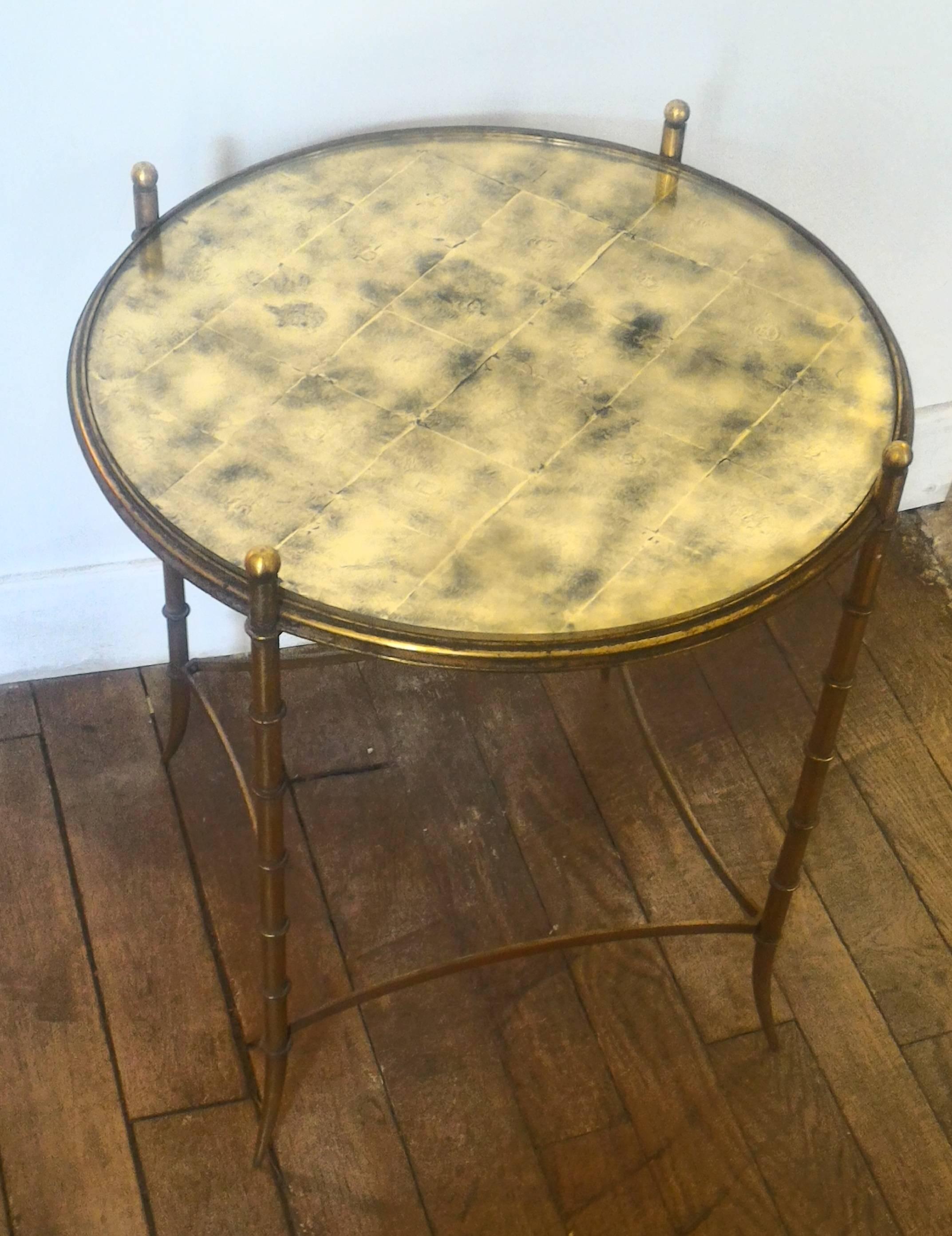 Pair of side tables in the style of Maison Jansen, made of metal with gold leaf.
French work realized in the 1950s.

Originally, the platter was made of glass but it was replaced by a altuglas platter.